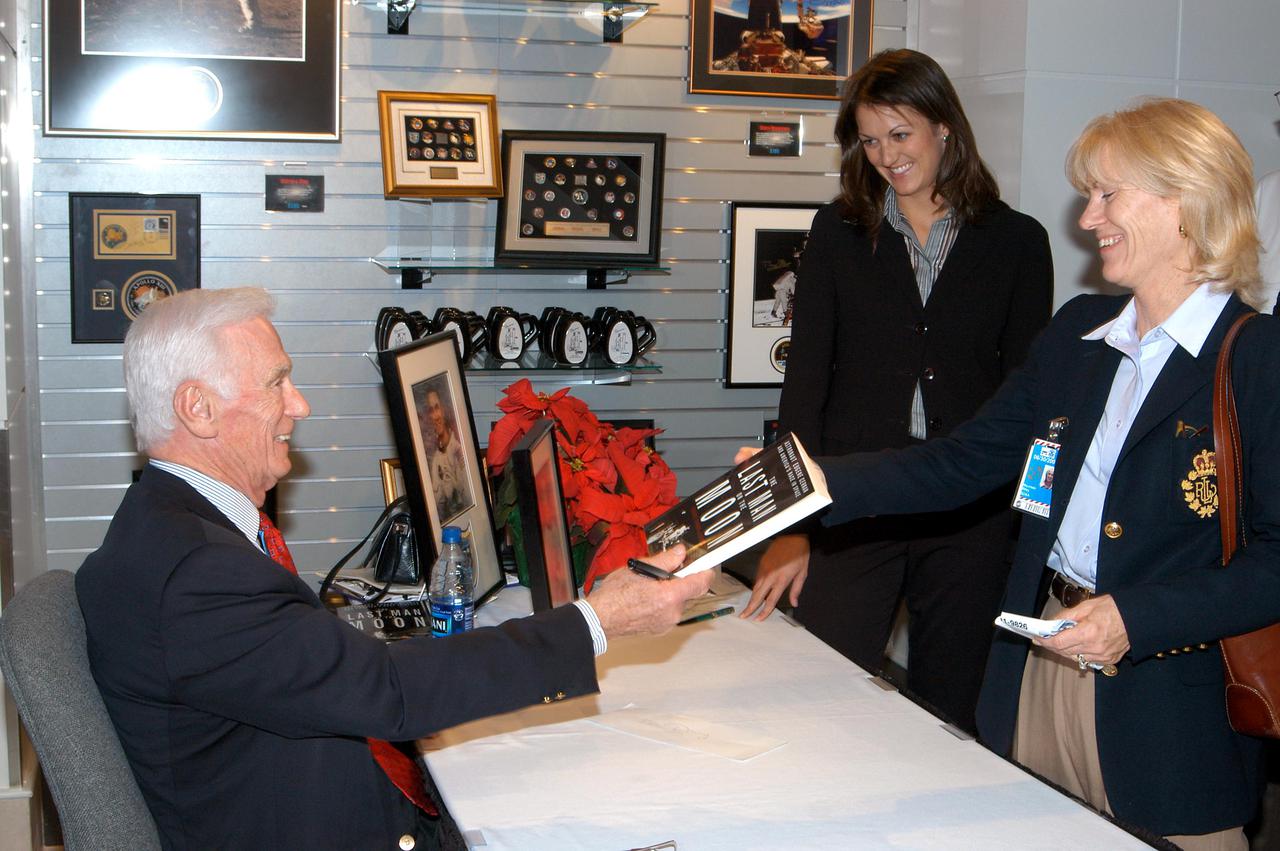 KENNEDY SPACE CENTER, FLA. -  Apollo 17 Commander Gene Cernan autographs his book for attendees at the grand opening ceremony of new Kennedy Space Center Store at Orlando International Airport.  NASA’s Kennedy Space Center Director Jim Kennedy and Cernan participated in the grand opening ceremony.  The store will help educate millions of airport visitors about America’s space program and the Vision for Space Exploration.  The store is operated by Kennedy Space Center Visitor Complex concessionaire Delaware North Parks and Resorts.