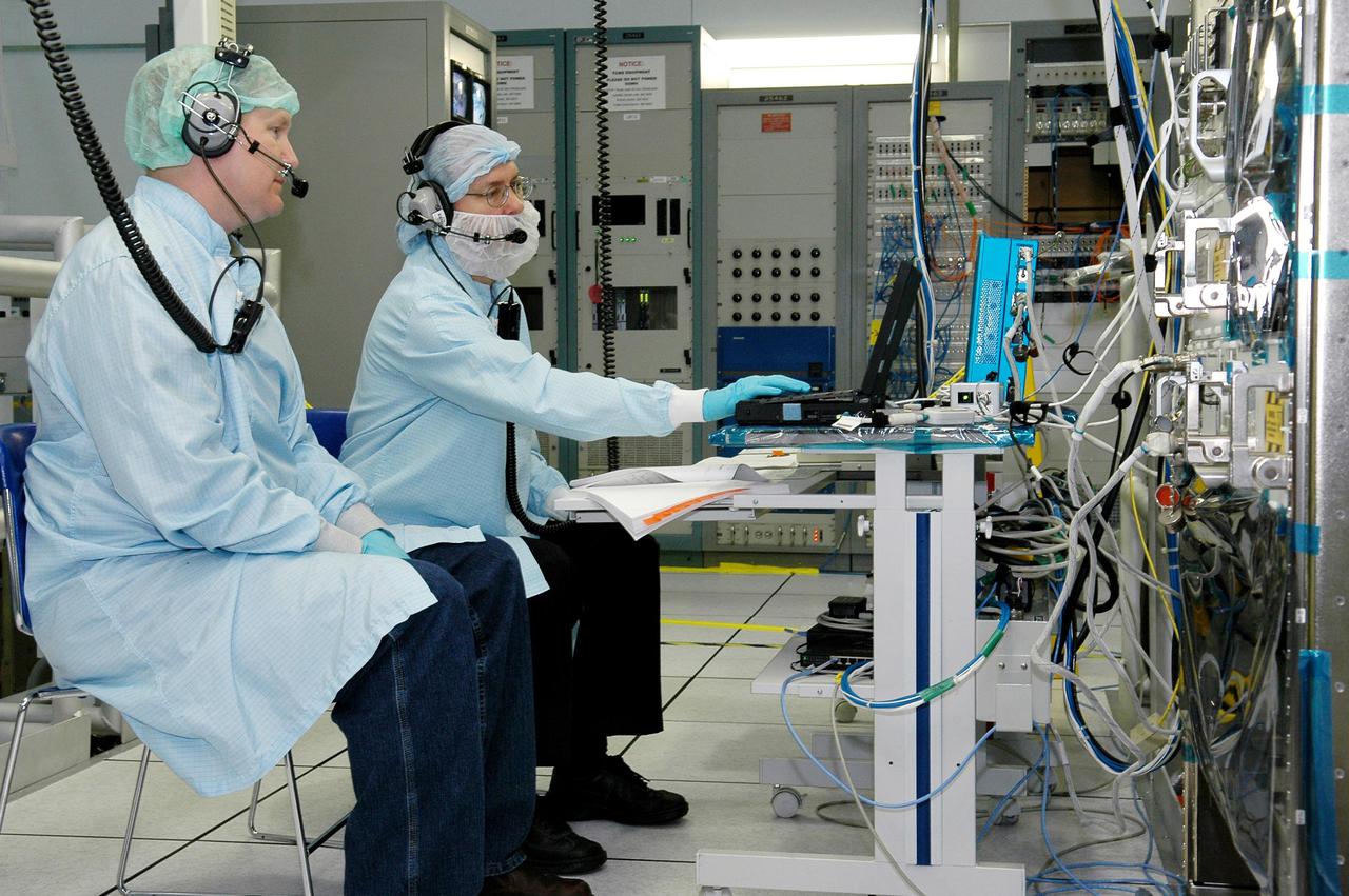 KENNEDY SPACE CENTER, FLA. -   -   In the Space Station Processing Facility, Gaschen Geissen and Elton Witt, with Lockheed Martin, monitor the Payload Test and Checkout System for the Human Research Facility (HRF) Rack -2 payload. The HRF-2 is scheduled to fly on Return to Flight Space Shuttle mission STS-114.  The HRF-2 will deliver additional biomedical instrumentation and research capability to the International Space Station.  HRF Rack 1 contains an ultrasound unit and gas analyzer system and has been operational in the U.S. Lab since May 2001.  HRF-2 will also be installed in the U. S. Lab and will provide structural, power, thermal, command and data handling, and communication and tracking interfaces between the HRF biomedical instrumentation and the U. S. Lab.