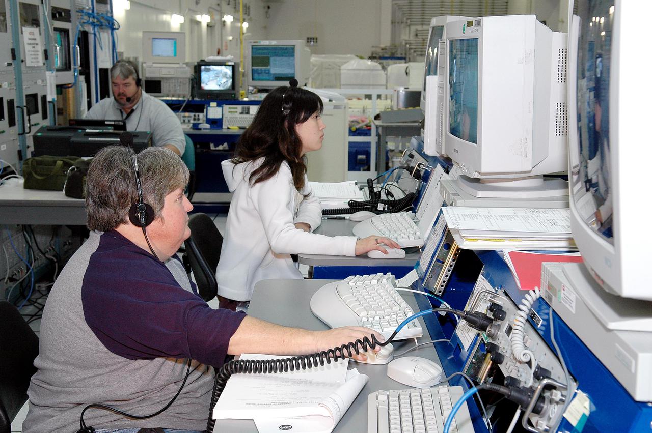 KENNEDY SPACE CENTER, FLA. -    Nancy Lowry (left) and Mikiko Ujihara, with Boeing, monitor the Payload Test and Checkout System for the Human Research Facility (HRF) Rack -2 payload. The HRF-2 is scheduled to fly on Return to Flight Space Shuttle mission STS-114.  The HRF-2 will deliver additional biomedical instrumentation and research capability to the International Space Station.  HRF Rack 1 contains an ultrasound unit and gas analyzer system and has been operational in the U.S. Lab since May 2001.  HRF-2 will also be installed in the U. S. Lab and will provide structural, power, thermal, command and data handling, and communication and tracking interfaces between the HRF biomedical instrumentation and the U. S. Lab.