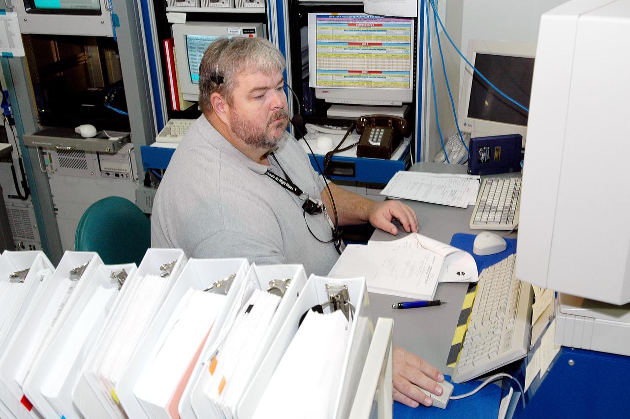 KENNEDY SPACE CENTER, FLA. -    Joe Mounts, with Boeing, monitors the Payload Test and Checkout System for the Human Research Facility (HRF) Rack -2 payload. The HRF-2 is scheduled to fly on Return to Flight Space Shuttle mission STS-114.  The HRF-2 will deliver additional biomedical instrumentation and research capability to the International Space Station.  HRF Rack 1 contains an ultrasound unit and gas analyzer system and has been operational in the U.S. Lab since May 2001.  HRF-2 will also be installed in the U. S. Lab and will provide structural, power, thermal, command and data handling, and communication and tracking interfaces between the HRF biomedical instrumentation and the U. S. Lab.