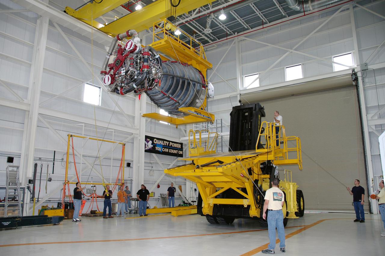 KENNEDY SPACE CENTER, FLA. -  In the Space Shuttle Main Engine (SSME) Shop, the SSME is lifted and moved toward the Hyster lift that will transport it to the Orbiter Processing Facility.  There it will be installed in the orbiter Discovery for Return to Flight mission STS-114. This is the third SSME to be installed in Discovery.  Overall, an SSME weighs approximately 7,000 pounds. An SSME operates at greater temperature extremes than any mechanical system in common use today. The liquid hydrogen fuel is -423 degrees Fahrenheit, the second coldest liquid on Earth. When the hydrogen is burned with liquid oxygen, the temperature in the engine's combustion chamber reaches +6000 degrees Fahrenheit -- higher than the boiling point of iron.  Each SSME is controlled by its own computer, which checks the health of the engines 50 times per second during countdown and ascent. The controller can shut an engine down if it detects a problem.