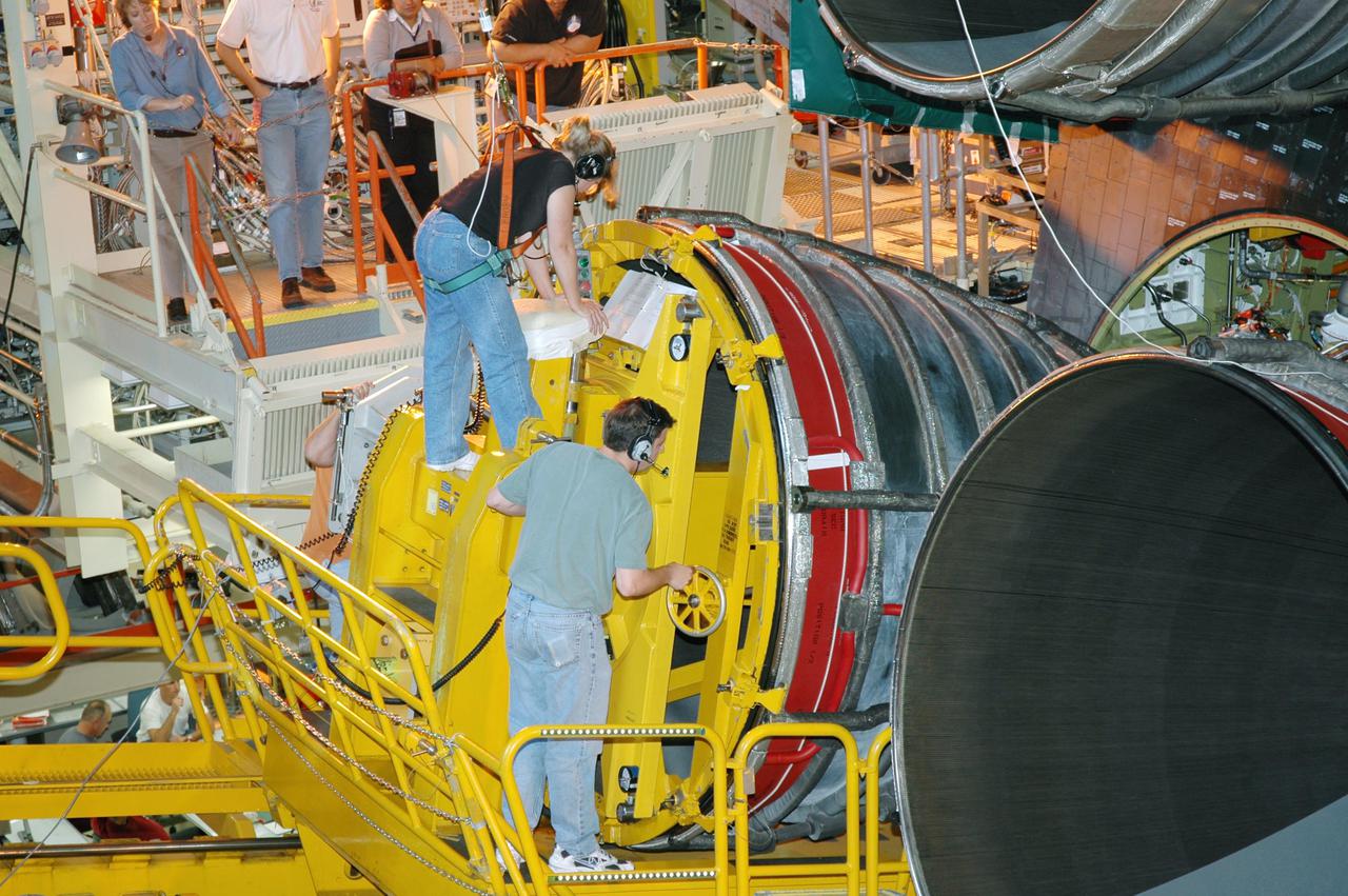 KENNEDY SPACE CENTER, FLA. - Technicians in the Orbiter Processing Facility carefully maneuver the third Space Shuttle Main Engine (SSME) into place on Discovery. Discovery is designated as the Return to Flight vehicle for mission STS-114. Recent improvements to the SSME include the introduction of redesigned high-pressure turbopumps into the SSME fleet. The new pumps are designed and built by Pratt and Whitney at West Palm Beach, Fla. SSMEs and the Pratt and Whitney turbopumps are tested at Stennis Space Center in Mississippi. Engines and engine components are delivered to Kennedy Space Center to be prepared for flight.