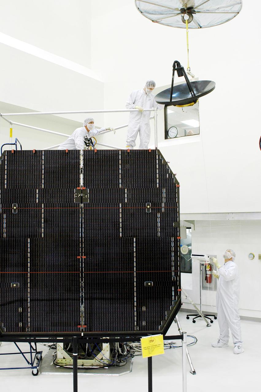 KENNEDY SPACE CENTER, FLA. -  Ball Aerospace technicians at Astrotech in Titusville, Fla., watch as the high-gain communications antenna is moved toward the Deep Impact spacecraft for installation. A NASA Discovery mission, Deep Impact will probe beneath the surface of Comet Tempel 1 on July 4, 2005, when the comet is 83 million miles from Earth, and reveal the secrets of its interior.   During the encounter phase, the high-gain antenna transmits near-real-time images of the impact back to Earth. The spacecraft is scheduled to launch Jan. 8 aboard a Boeing Delta II rocket from Launch Complex 17-B at Cape Canaveral Air Force Station, Fla.