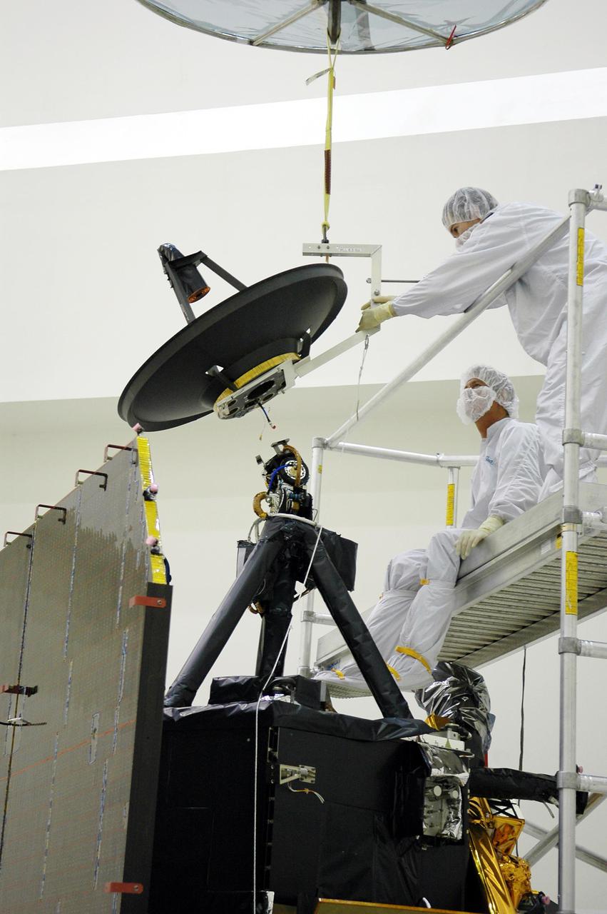 KENNEDY SPACE CENTER, FLA. -  Ball Aerospace technicians at Astrotech in Titusville, Fla., guide the high-gain communications antenna toward the attach-point on the Deep Impact spacecraft. A NASA Discovery mission, Deep Impact will probe beneath the surface of Comet Tempel 1 on July 4, 2005, when the comet is 83 million miles from Earth, and reveal the secrets of its interior.   During the encounter phase, the high-gain antenna transmits near-real-time images of the impact back to Earth. The spacecraft is scheduled to launch Jan. 8 aboard a Boeing Delta II rocket from Launch Complex 17-B at Cape Canaveral Air Force Station, Fla.
