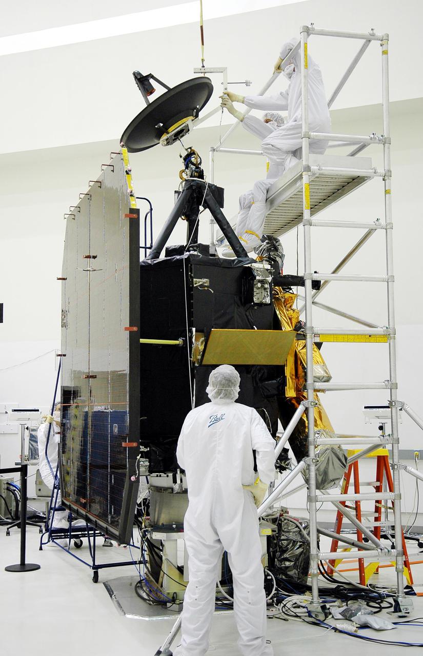 KENNEDY SPACE CENTER, FLA. -  Ball Aerospace technicians at Astrotech in Titusville, Fla., guide the high-gain communications antenna toward the attach-point on the Deep Impact spacecraft. A NASA Discovery mission, Deep Impact will probe beneath the surface of Comet Tempel 1 on July 4, 2005, when the comet is 83 million miles from Earth, and reveal the secrets of its interior.   During the encounter phase, the high-gain antenna transmits near-real-time images of the impact back to Earth. The spacecraft is scheduled to launch Jan. 8 aboard a Boeing Delta II rocket from Launch Complex 17-B at Cape Canaveral Air Force Station, Fla.