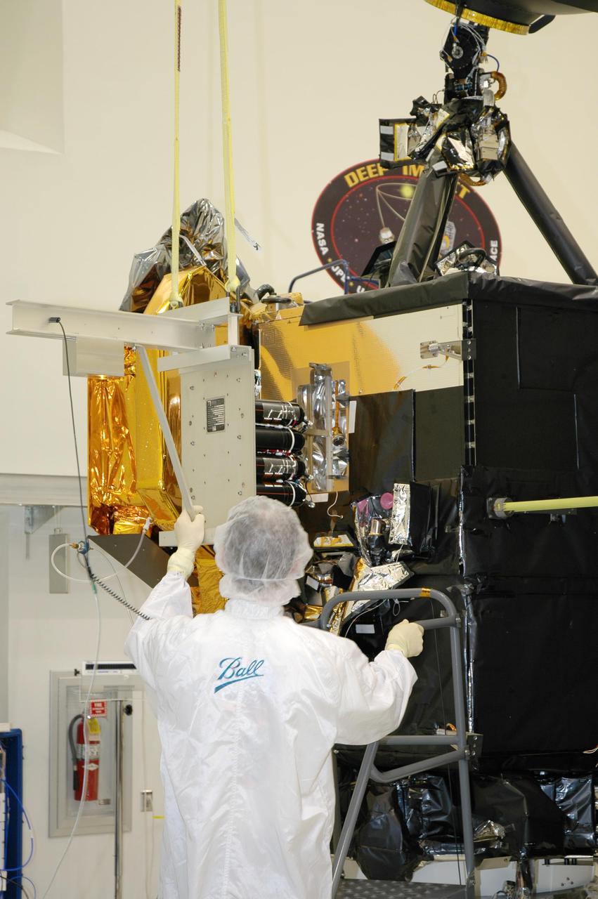 KENNEDY SPACE CENTER, FLA. - At Astrotech Space Operations in Titusville, Fla., a Ball Aerospace technician helps guide the flight battery toward the flyby spacecraft on Deep Impact where it will be installed. About the size of a Ford Explorer, the flyby spacecraft is three-axis stabilized and uses a fixed solar array and a small NiH2 battery for its power system. A NASA Discovery mission, Deep Impact will probe beneath the surface of Comet Tempel 1 on July 4, 2005, when the comet is 83 million miles from Earth. During the encounter phase when the comet collides with the impactor projectile propelled into its path, the spacecraft’s high-gain antenna will transmit near-real-time images of the impact back to Earth. The spacecraft is scheduled to launch Jan. 8 aboard a Boeing Delta II rocket from Launch Complex 17-B at Cape Canaveral Air Force Station, Fla.