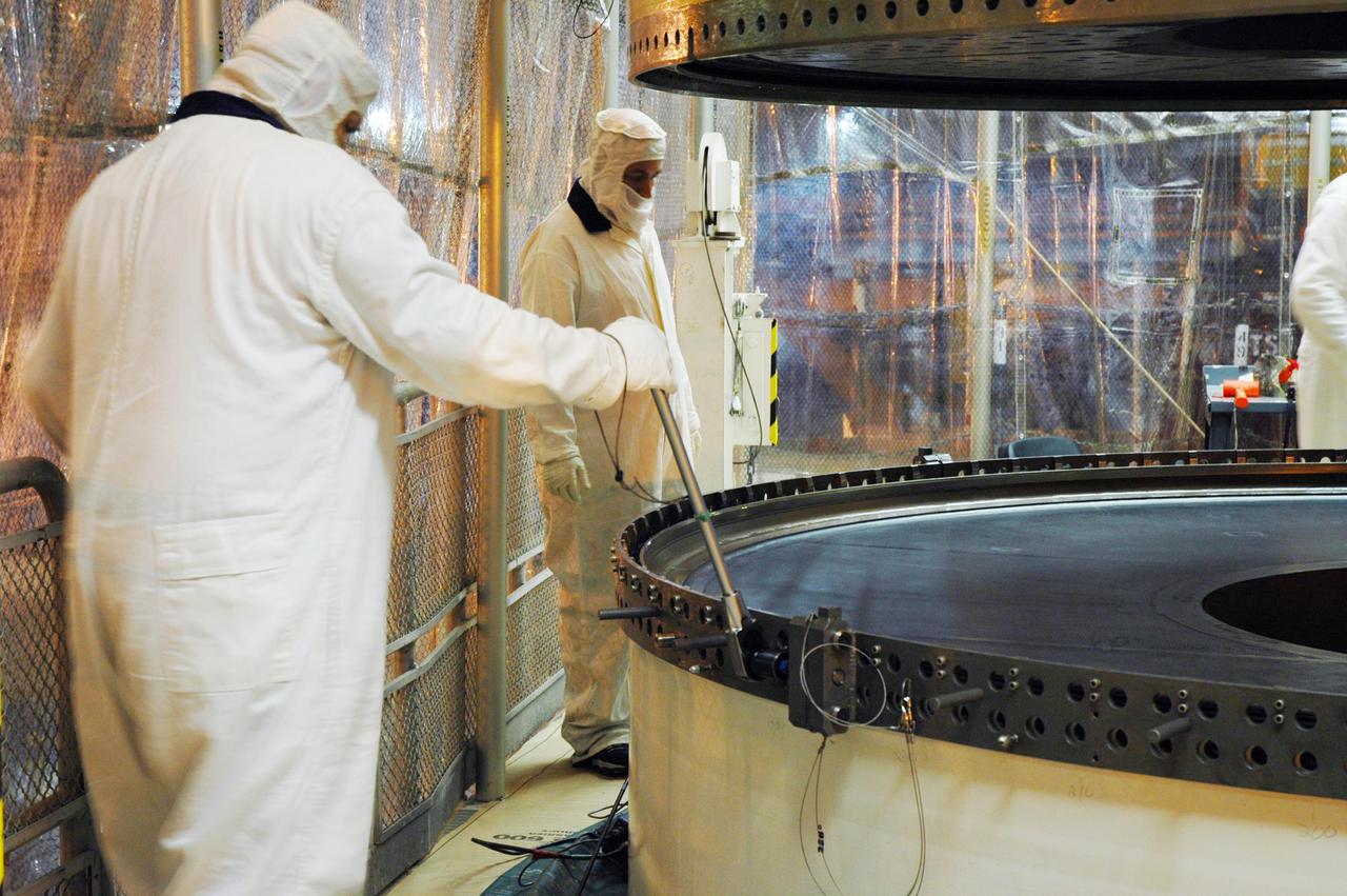 KENNEDY SPACE CENTER, FLA. - In a Vehicle Assembly Building (VAB) high bay, workers check the alignment of a Solid Rocket Booster (SRB) aft center segment as it is lowered toward an aft segment already secured to a Mobile Launch Platform. These segments are part of the right SRB for the Space Shuttle Return to Flight mission, STS-114. Two SRBs are stacked on a Mobile Launch Platform for each Shuttle flight and later joined by an External Tank. The twin 149-foot tall, 12-foot diameter SRBs provide the main propulsion system during launch. They operate in parallel with the Space Shuttle main engines for the first two minutes of flight and jettison away from the orbiter with help from the Booster Separation Motors, about 26.3 nautical miles above the Earth’s surface.