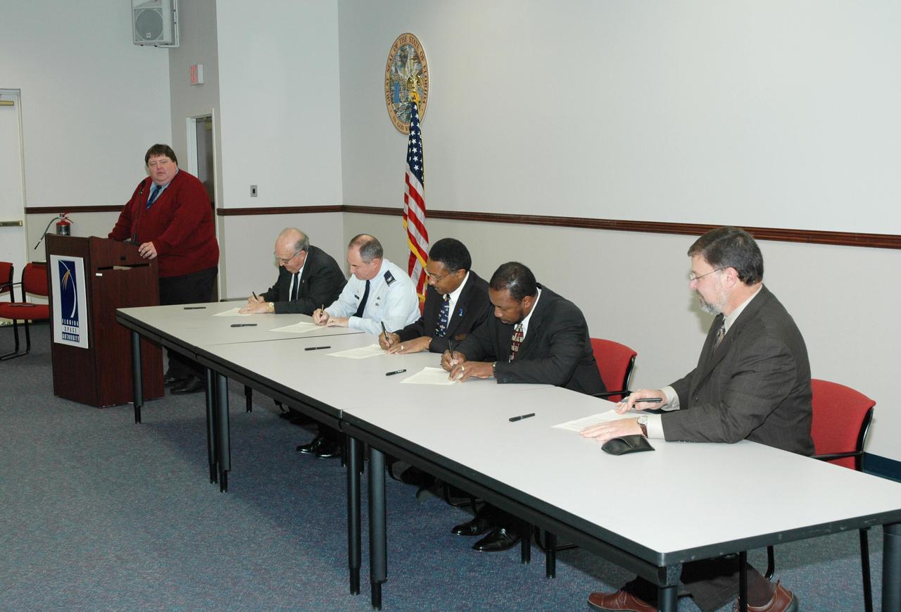KENNEDY SPACE CENTER, FLA. -  Leaders of prominent Florida space organizations convened at the Florida Space Authority campus in Cape Canaveral to sign a memorandum of agreement with the Space Foundation to launch the first “Florida Space” conference. From left are Jim Banke (at podium), vice president of Florida operations for the Space Foundation; Dr. James W. Johnson, chairman of the Canaveral Council of Technical Societies; Col. Mark H. Owen, commander of the 45th Space Wing at Patrick Air Force Base; retired Navy Capt. Winston E. Scott, executive director of the Florida Space Authority; Dr. Woodrow Whitlow Jr., deputy director of the Kennedy Space Center; and Elliot G. Pulham, president and chief executive officer of the Space Foundation. The conference will combine and build on the best features of previous Florida space events including Space Congress and the Cape Canaveral Spaceport Symposium. Both will be retired now in favor of this new event to be held annually and operated by the Space Foundation. Florida Space 2005 will be presented in November 2005.