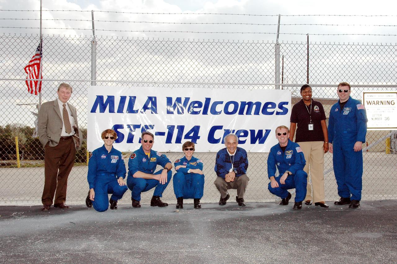 KENNEDY SPACE CENTER, FLA. - Outside the MILA Spaceflight Tracking and Data Network Station during a visit to Kennedy, members of the STS-114 crew pause for a photo with Anthony Ippolito (far left), current director of MILA_PDL. (MILA refers to Merritt Island Launch Area; PDL designates the Ponce De Leon Inlet site.). The crew members are (left to right) commander Eileen Collins, Mission Specialists Stephen Robinson, Wendy Lawrence and Andrew Thomas; and Pilot James Kelly. Between Lawrence and Thomas is Gary Morse (left), incumbent MILA_PDL station director. Between Thomas and Kelly is Melissa Blizzard, MILA operations manager. The tracking station serves as the primary voice, data and telemetry communications link between the Shuttle and the ground from launch until 7-1_2 minutes into the flight. Millions of clues about the performance of the Space Shuttle’s main engines and other components are communicated to launch managers, technicians and engineers on the ground, who must keep their fingers on the pulse of the Space Shuttle during the critical ascent period. In a typical year, MILA provides through KSC more than 10,000 hours of data between spacecraft and data users. MILA is also used during a Space Shuttle landing at KSC and provides communications beginning about 13 minutes before touchdown. Also, MILA can be called upon to provide data transfer support for NASA’s Expendable Launch Vehicle missions and orbiting scientific satellites.