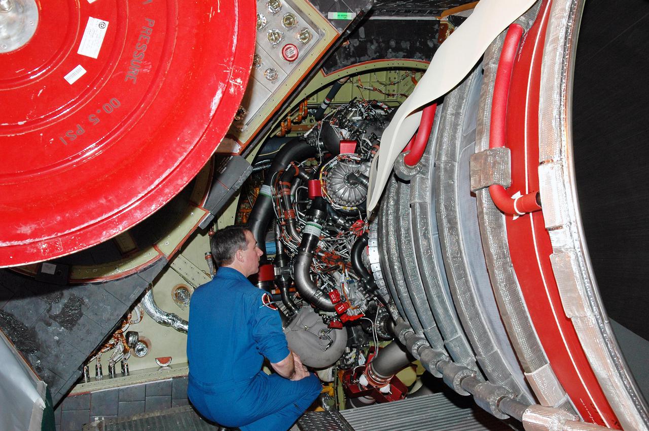 KENNEDY SPACE CENTER, FLA. -  On a visit to Kennedy, STS-114 Mission Specialist Stephen Robinson views closely one of the main engines recently installed on Discovery, the designated vehicle for the mission.  Discovery is in the Orbiter Processing Facility for launch processing. Discovery is scheduled for a launch planning window of May 12 to June 3, 2005.
