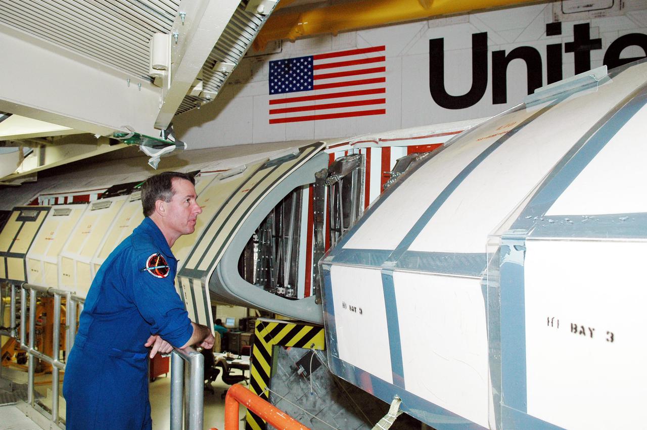 KENNEDY SPACE CENTER, FLA. -  On a visit to Kennedy, STS-114 Mission Specialist Stephen Robinson looks inside the wing of the orbiter Discovery, which is in the Orbiter Processing Facility for launch processing. Discovery is scheduled for a launch planning window of May 12 to June 3, 2005.