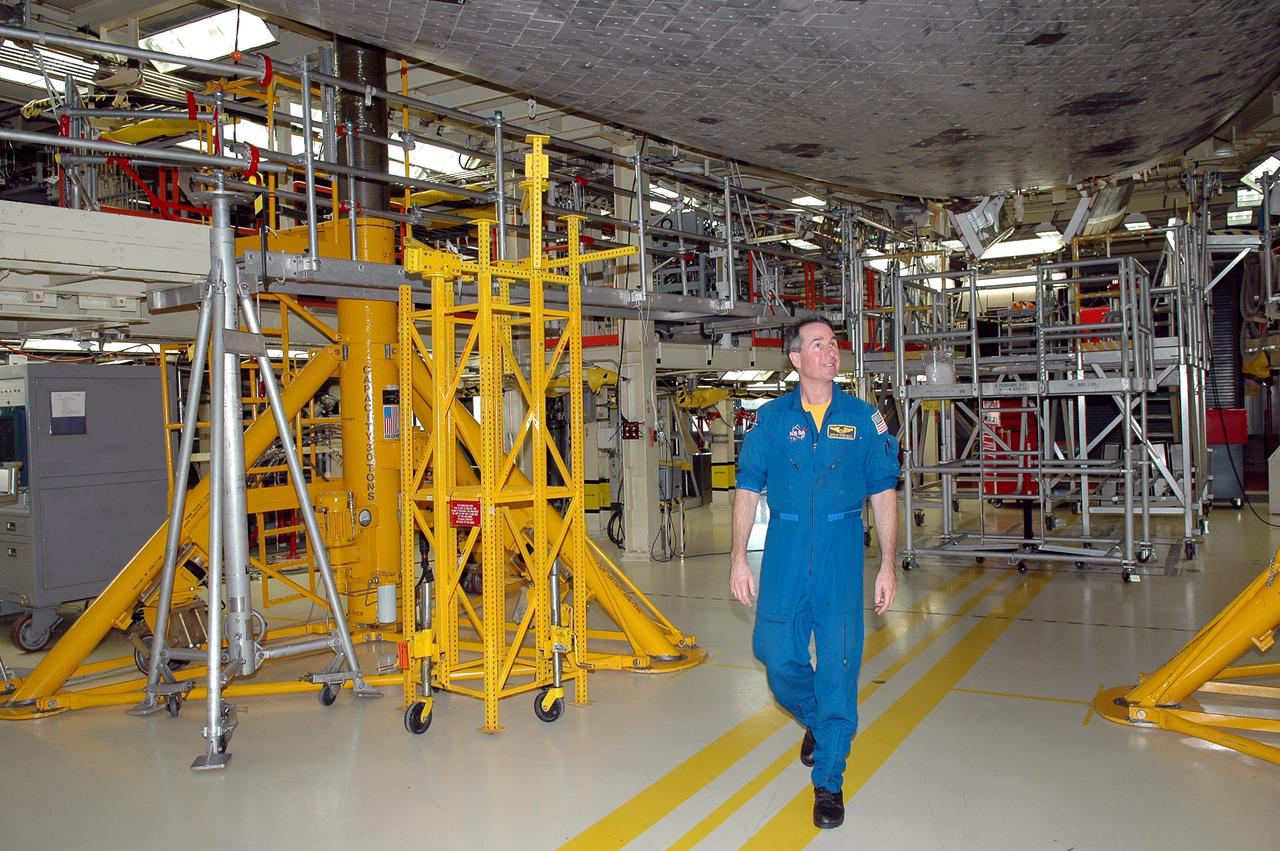 KENNEDY SPACE CENTER, FLA. - On a visit to Kennedy, STS-114 Mission Specialist Stephen Robinson looks at the tiles, part of the Thermal Protection System, on the belly of the orbiter Discovery. The designated vehicle for the mission, Discovery is in the Orbiter Processing Facility for launch processing. Discovery is scheduled for a launch planning window of May 12 to June 3, 2005.