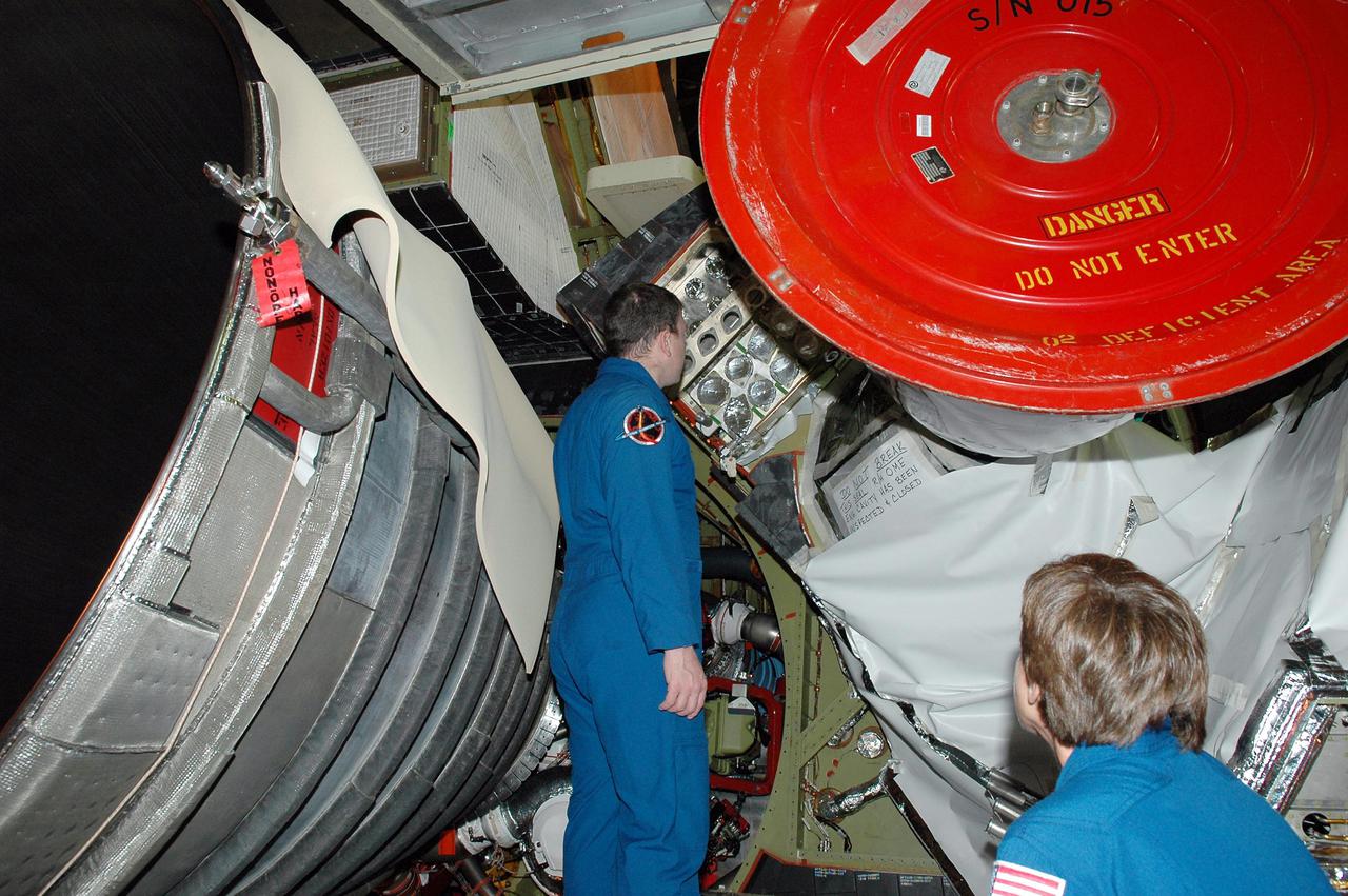KENNEDY SPACE CENTER, FLA. -  On a visit to Kennedy, STS-114 James Kelly looks closely at an area of an engine on the orbiter Discovery.  The main engines were recently installed.  The designated vehicle for the mission, Discovery is in the Orbiter Processing Facility for launch processing. Discovery is scheduled for a launch planning window of May 12 to June 3, 2005.