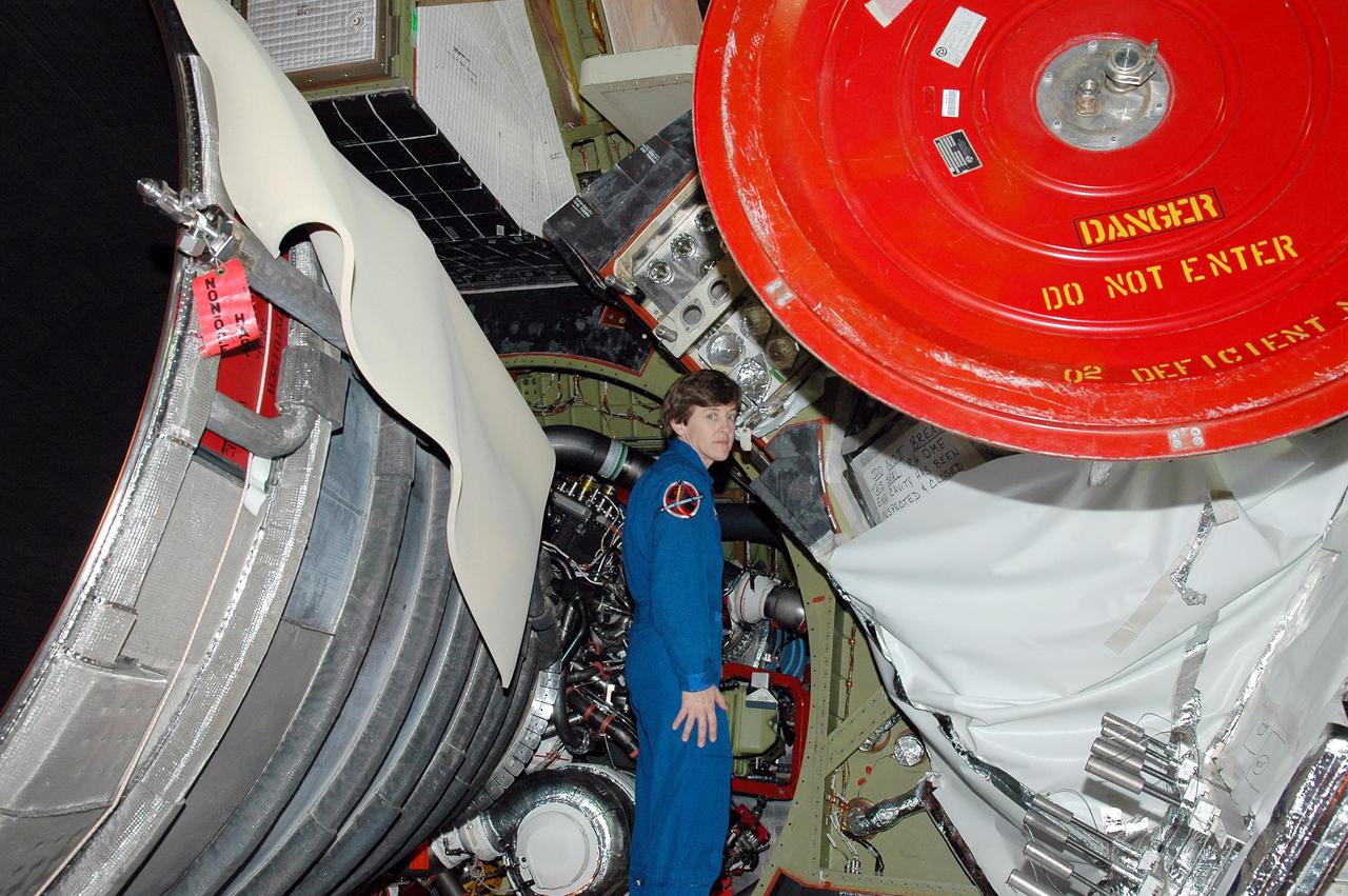 KENNEDY SPACE CENTER, FLA. -  On a visit to Kennedy, STS-114 Mission Specialist Wendy Lawrence looks at an area of an engine on the orbiter Discovery.  The main engines were recently installed.  The designated vehicle for the mission, Discovery is in the Orbiter Processing Facility for launch processing. Discovery is scheduled for a launch planning window of May 12 to June 3, 2005.