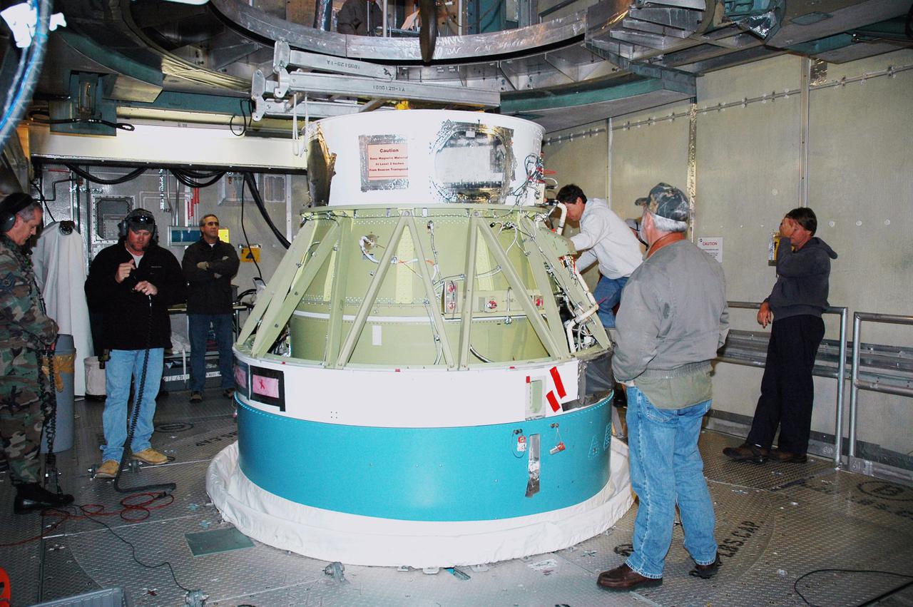 KENNEDY SPACE CENTER, FLA. -  In the mobile service tower on Pad 17-B, Cape Canaveral Air Force Station, Fla., Boeing technicians prepare to demate the second stage of the Boeing Delta II rocket that will launch the Deep Impact spacecraft.  Removal of the second stage will allow workers to then remove the rocket’s inter-stage adapter, which was found to be faulty during a review of launch vehicle hardware.  It will be replaced and the second stage re-installed within a few days.  Launch of Deep Impact is now scheduled no earlier than Jan. 12.