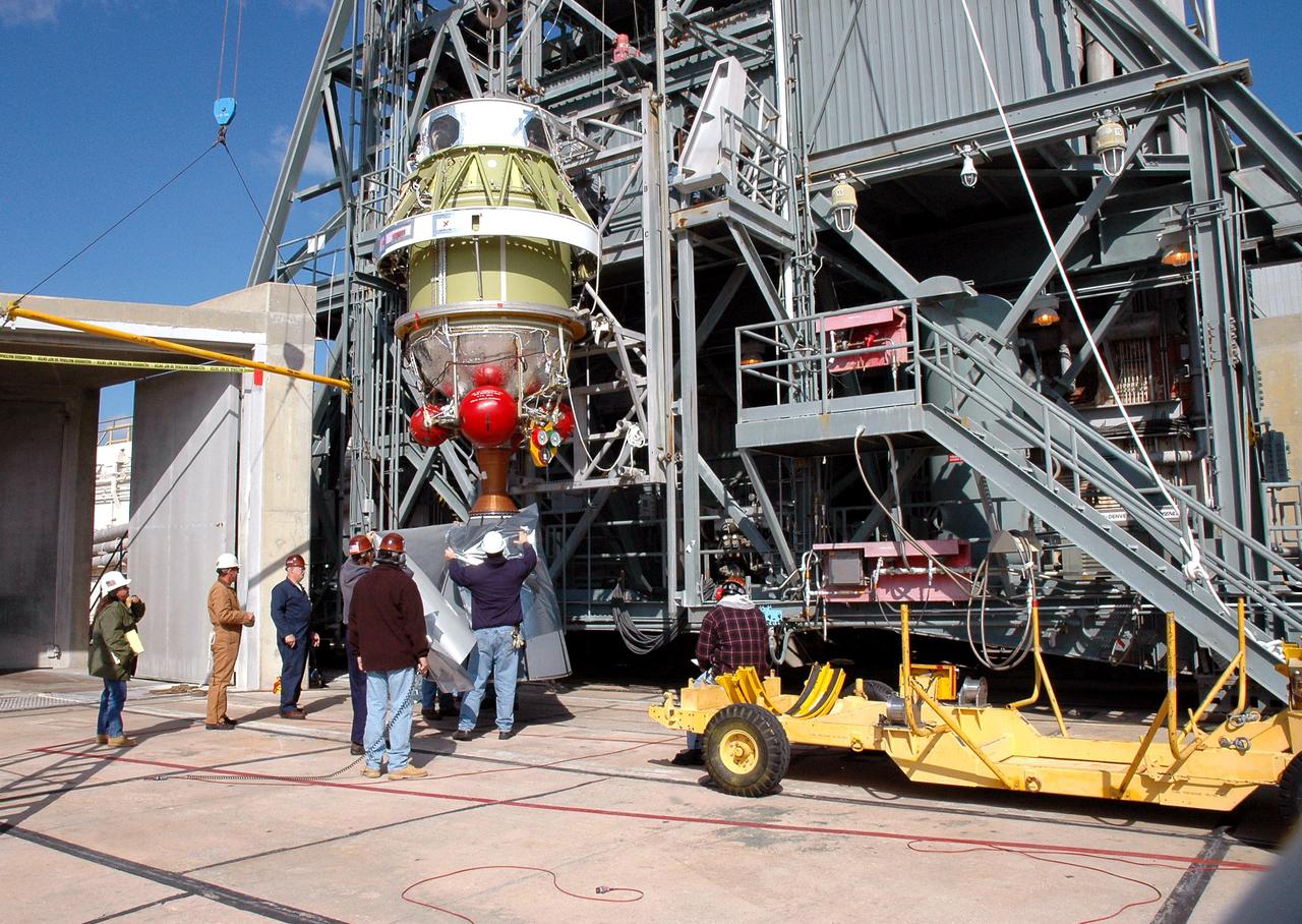 KENNEDY SPACE CENTER, FLA. - After removal from the Boeing Delta II rocket, the second stage is lowered to the ground. It will be stored temporarily until the inter-stage adapter on the rocket can be replaced. Removal of the second stage will allow workers to then remove the rocket’s inter-stage adapter, which was found to be faulty during a review of launch vehicle hardware. It will be replaced and the second stage re-installed within a few days. Launch of Deep Impact is now scheduled no earlier than Jan. 12.