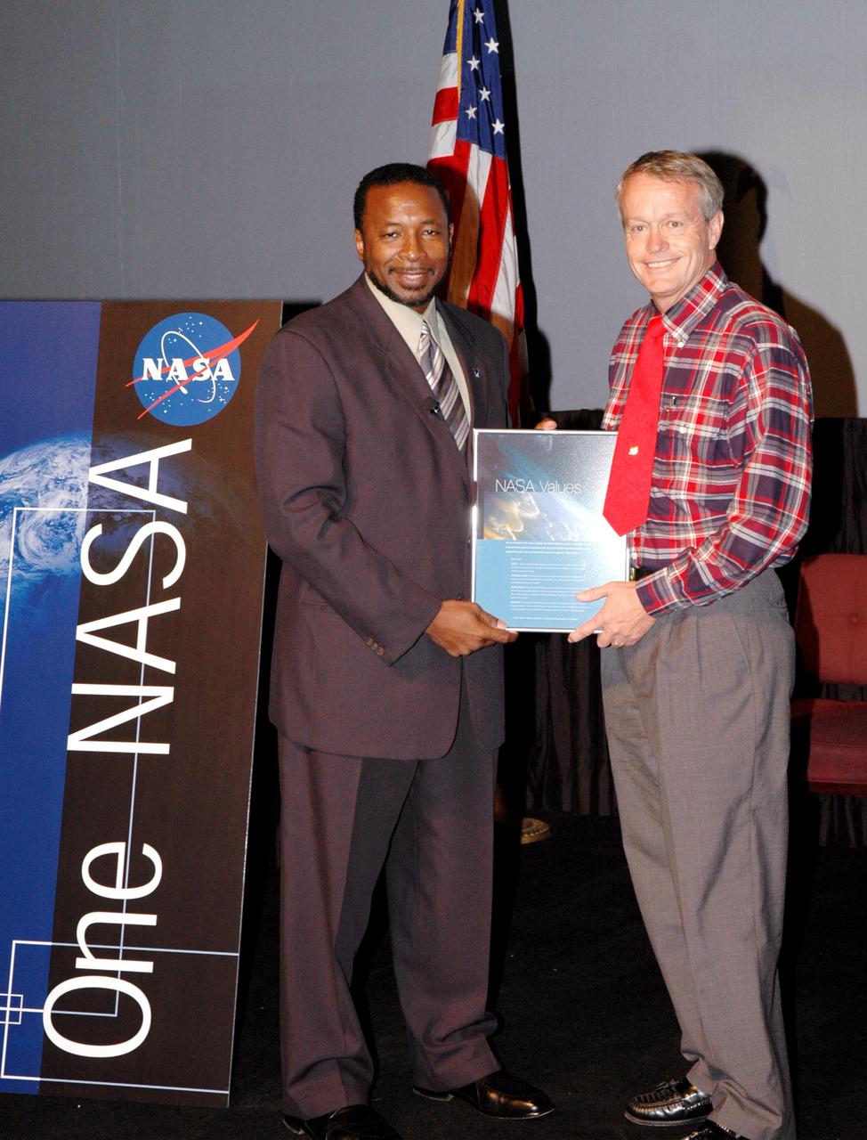 KENNEDY SPACE CENTER, FLA. -  Kennedy’s Deputy Director Woodrow Whitlow Jr. presents Ronny Goodin an award for a winning entry in the NASA Values essay contest. The award was presented during the One NASA Leader-Led Workshop, which presented senior leadership in the Agency talking about ongoing Transformation activities and Kennedy’s role in the Vision for Space Exploration.