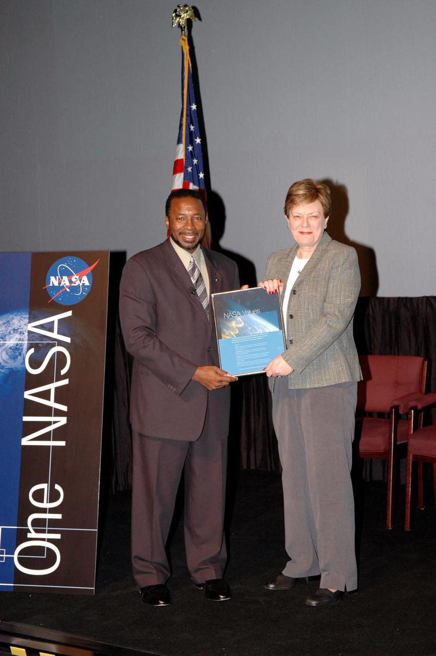 KENNEDY SPACE CENTER, FLA. -  Kennedy’s Deputy Director Woodrow Whitlow Jr. presents Carol Anne Dunn an award for a winning entry in the NASA Values essay contest. The award was presented during the One NASA Leader-Led Workshop, which presented senior leadership in the Agency talking about ongoing Transformation activities and Kennedy’s role in the Vision for Space Exploration.