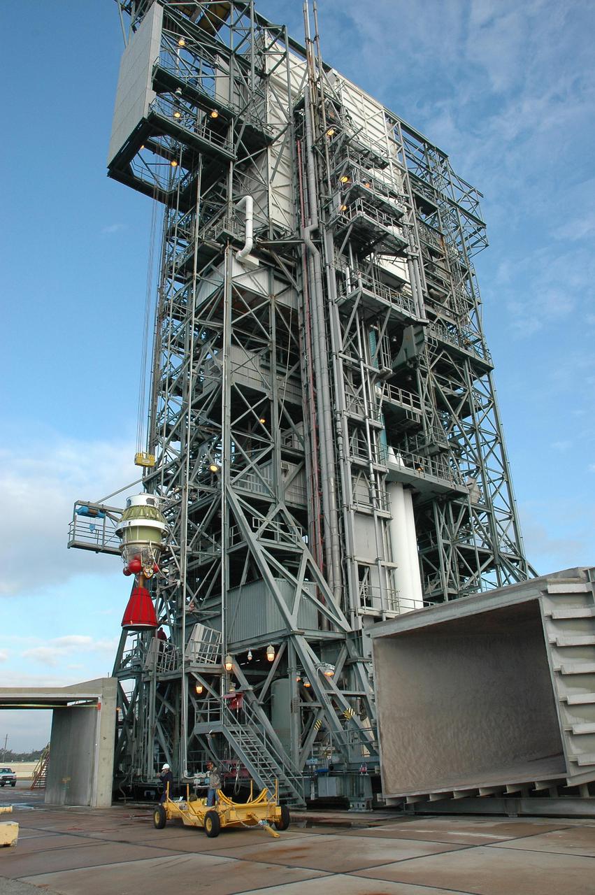 KENNEDY SPACE CENTER, FLA. -  At Launch Pad 17-B, Cape Canaveral Air Force Station, the Boeing Delta II second stage is lifted up the mobile service tower.  The component will be reattached to the interstage adapter on the Delta II.  The rocket is the launch vehicle for the Deep Impact spacecraft, scheduled for liftoff no earlier than Jan. 12.  A NASA Discovery mission, Deep Impact will probe beneath the surface of Comet Tempel 1 on July 4, 2005, when the comet is 83 million miles from Earth, and reveal the secrets of its interior.   After releasing a 3- by 3-foot projectile to crash onto the surface, Deep Impact’s flyby spacecraft will collect pictures and data of how the  crater forms, measuring the crater’s depth and diameter, as well as the composition of the interior of the crater and any material thrown out, and determining the changes in natural outgassing produced by the impact.  It will send the data back to Earth through the antennas of the Deep Space Network.