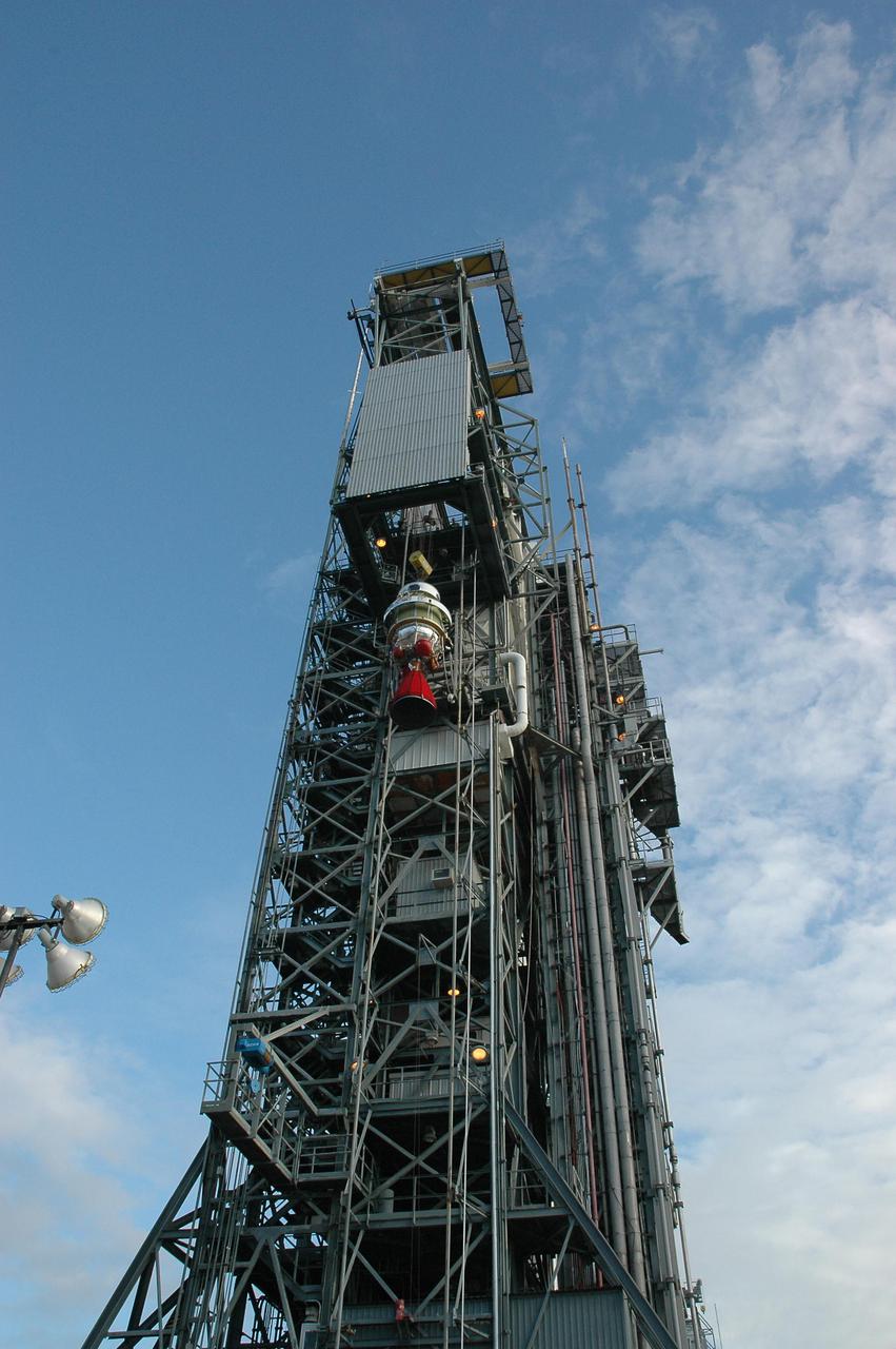 KENNEDY SPACE CENTER, FLA. -  At Launch Pad 17-B, Cape Canaveral Air Force Station, the Boeing Delta II second stage reaches the top of the mobile service tower.  The component will be reattached to the interstage adapter on the Delta II.  The rocket is the launch vehicle for the Deep Impact spacecraft, scheduled for liftoff no earlier than Jan. 12.  A NASA Discovery mission, Deep Impact will probe beneath the surface of Comet Tempel 1 on July 4, 2005, when the comet is 83 million miles from Earth, and reveal the secrets of its interior.   After releasing a 3- by 3-foot projectile to crash onto the surface, Deep Impact’s flyby spacecraft will collect pictures and data of how the  crater forms, measuring the crater’s depth and diameter, as well as the composition of the interior of the crater and any material thrown out, and determining the changes in natural outgassing produced by the impact.  It will send the data back to Earth through the antennas of the Deep Space Network.