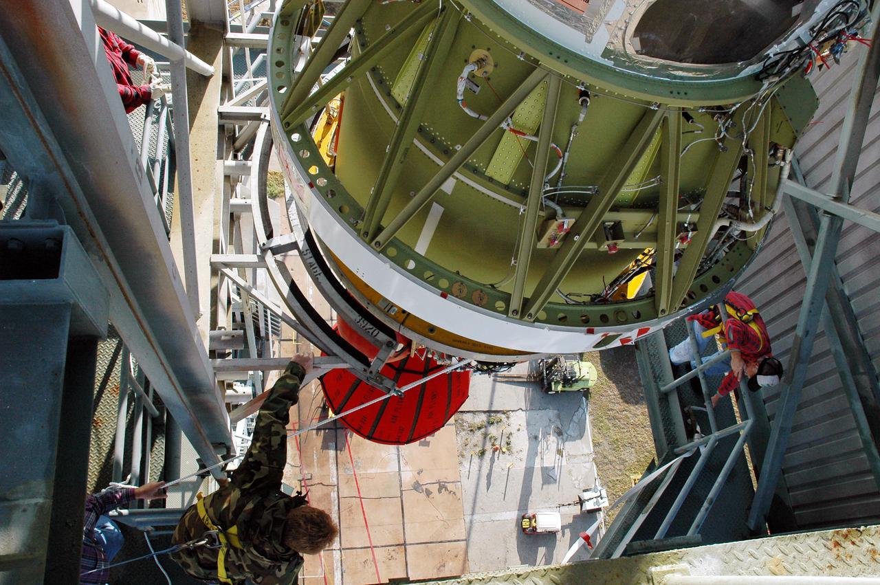 KENNEDY SPACE CENTER, FLA. -  This view from inside the mobile service tower on Launch Pad 17-B, Cape Canaveral Air Force Station, shows the Boeing Delta II second stage as it reaches the top.  The component will be reattached to the interstage adapter on the Delta II.  The rocket is the launch vehicle for the Deep Impact spacecraft, scheduled for liftoff no earlier than Jan. 12.  A NASA Discovery mission, Deep Impact will probe beneath the surface of Comet Tempel 1 on July 4, 2005, when the comet is 83 million miles from Earth, and reveal the secrets of its interior.   After releasing a 3- by 3-foot projectile to crash onto the surface, Deep Impact’s flyby spacecraft will collect pictures and data of how the  crater forms, measuring the crater’s depth and diameter, as well as the composition of the interior of the crater and any material thrown out, and determining the changes in natural outgassing produced by the impact.  It will send the data back to Earth through the antennas of the Deep Space Network.