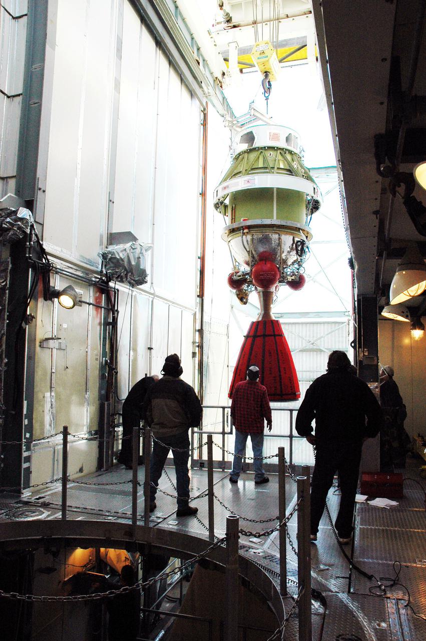 KENNEDY SPACE CENTER, FLA. - This view from inside the mobile service tower on Launch Pad 17-B, Cape Canaveral Air Force Station, shows the Boeing Delta II second stage as it reaches the top. The component will be reattached to the interstage adapter on the Delta II. The rocket is the launch vehicle for the Deep Impact spacecraft, scheduled for liftoff no earlier than Jan. 12. A NASA Discovery mission, Deep Impact will probe beneath the surface of Comet Tempel 1 on July 4, 2005, when the comet is 83 million miles from Earth, and reveal the secrets of its interior. After releasing a 3- by 3-foot projectile to crash onto the surface, Deep Impact’s flyby spacecraft will collect pictures and data of how the crater forms, measuring the crater’s depth and diameter, as well as the composition of the interior of the crater and any material thrown out, and determining the changes in natural outgassing produced by the impact. It will send the data back to Earth through the antennas of the Deep Space Network.