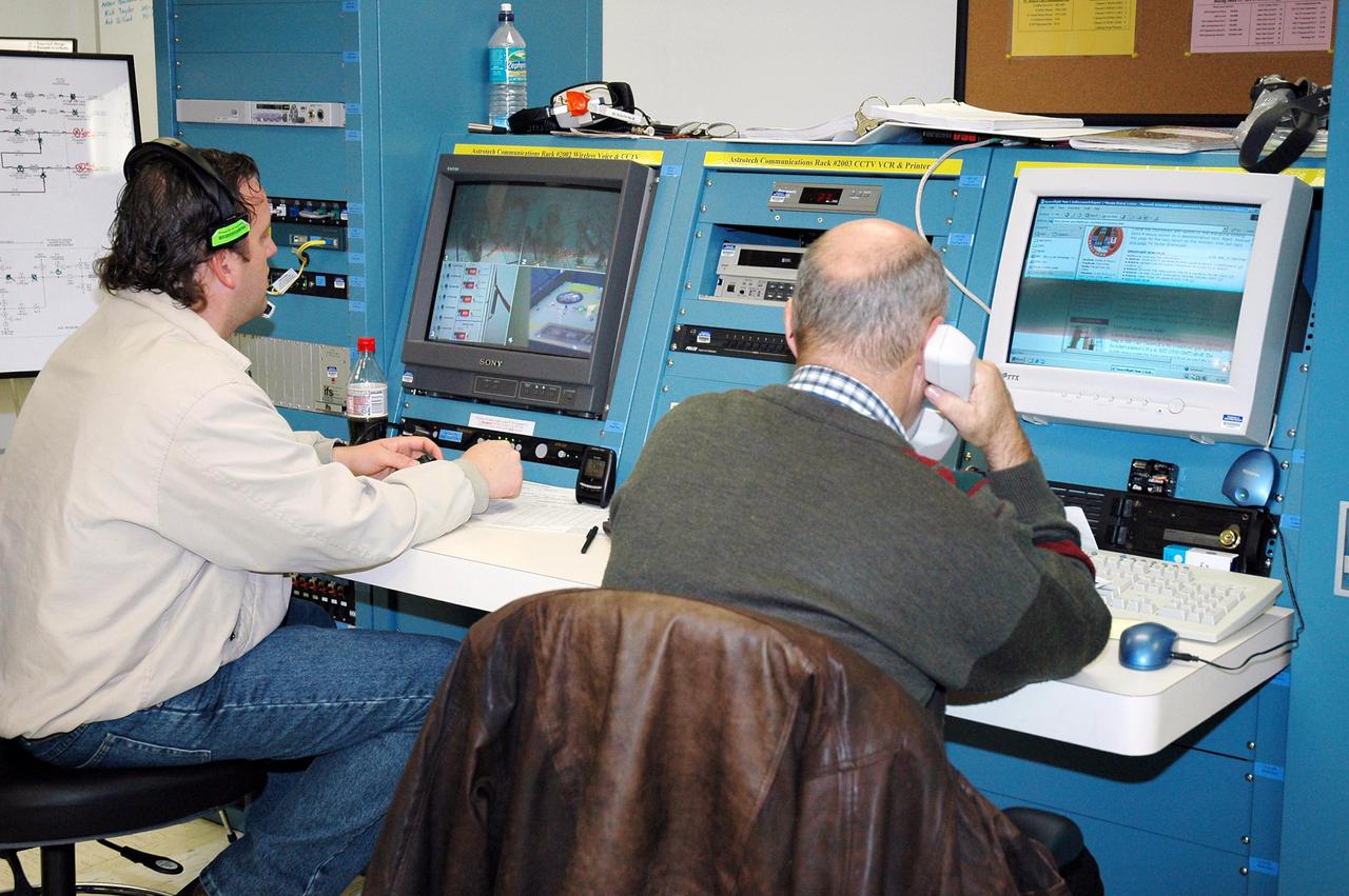 KENNEDY SPACE CENTER, FLA. -  Workers at Astrotech Space Operations in Titusville, Fla., monitor the fueling operations of the Deep Impact spacecraft. Scheduled for liftoff Jan. 12,  Deep Impact will probe beneath the surface of Comet Tempel 1 on July 4, 2005, when the comet is 83 million miles from Earth, and reveal the secrets of its interior.   After releasing a 3- by 3-foot projectile to crash onto the surface, Deep Impact’s flyby spacecraft will collect pictures and data of how the  crater forms, measuring the crater’s depth and diameter, as well as the composition of the interior of the crater and any material thrown out, and determining the changes in natural outgassing produced by the impact.  It will send the data back to Earth through the antennas of the Deep Space Network.  Deep Impact is a NASA Discovery mission.