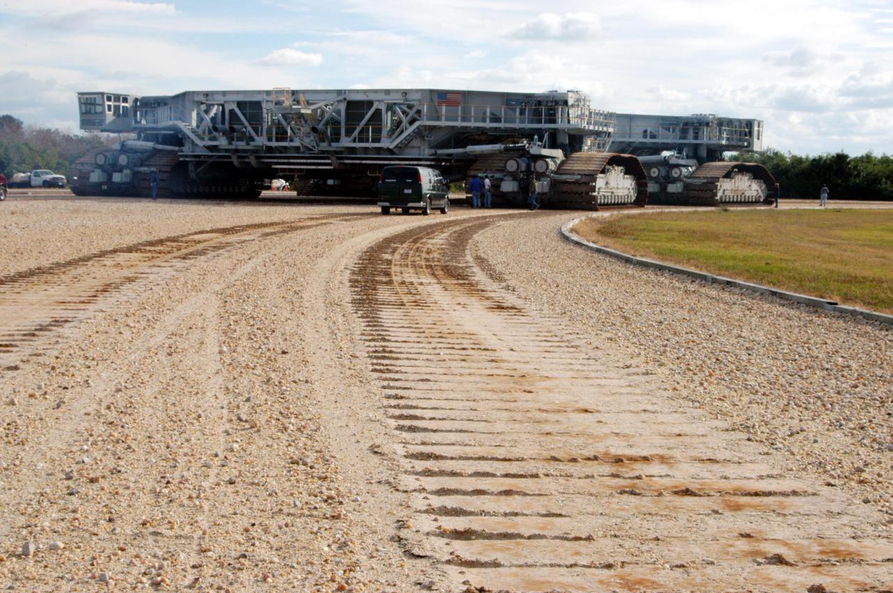KENNEDY SPACE CENTER, FLA. - The newly shod Crawler Transporter leaves tracks in the dirt as it moves forward on its road test. The Crawler Transporter that will move Space Shuttle Discovery to the launch pad for Return to Flight is taking its first road test following the replacement of all its shoes. The crawlers have 456 shoes, 57 per belt (8 belts in all). Each shoe weighs 2,200 pounds. Cracks appeared in the shoes in recent years, spurring a need for replacement. The new manufacturer, in Duluth, Minn., has improved the design for a safe Return to Flight and use through the balance of the Space Shuttle Program.
