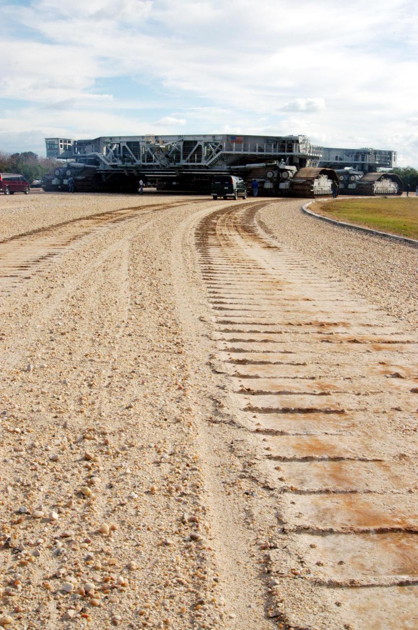 KENNEDY SPACE CENTER, FLA. - The newly shod Crawler Transporter leaves tracks in the dirt as it moves forward on its road test. The Crawler Transporter that will move Space Shuttle Discovery to the launch pad for Return to Flight is taking its first road test following the replacement of all its shoes. The crawlers have 456 shoes, 57 per belt (8 belts in all). Each shoe weighs 2,200 pounds. Cracks appeared in the shoes in recent years, spurring a need for replacement. The new manufacturer, in Duluth, Minn., has improved the design for a safe Return to Flight and use through the balance of the Space Shuttle Program.