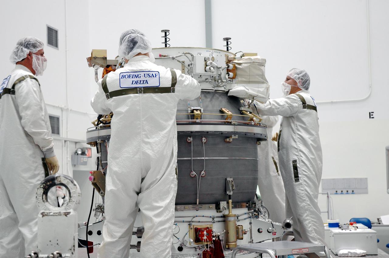 KENNEDY SPACE CENTER, FLA. - Boeing technicians at Astrotech Space Operations in Titusville, Fla., prepare the third stage of a Delta II rocket for mating with the Deep Impact spacecraft. When the spacecraft and third stage are mated, they will be moved to Launch Pad 17-B at Cape Canaveral Air Force Station, Fla.  There they will be mated to the Delta II rocket and the fairing installed around them for protection during launch and ascent.  Scheduled for liftoff Jan. 12,  Deep Impact will probe beneath the surface of Comet Tempel 1 on July 4, 2005, when the comet is 83 million miles from Earth.  After releasing a 3- by 3-foot projectile to crash onto the surface, Deep Impact’s flyby spacecraft will reveal the secrets of its interior by collecting pictures and data of how the crater forms, measuring the crater’s depth and diameter as well as the composition of the interior of the crater and any material thrown out, and determining the changes in natural outgassing produced by the impact.  It will send the data back to Earth through the antennas of the Deep Space Network.  Deep Impact is a NASA Discovery mission.