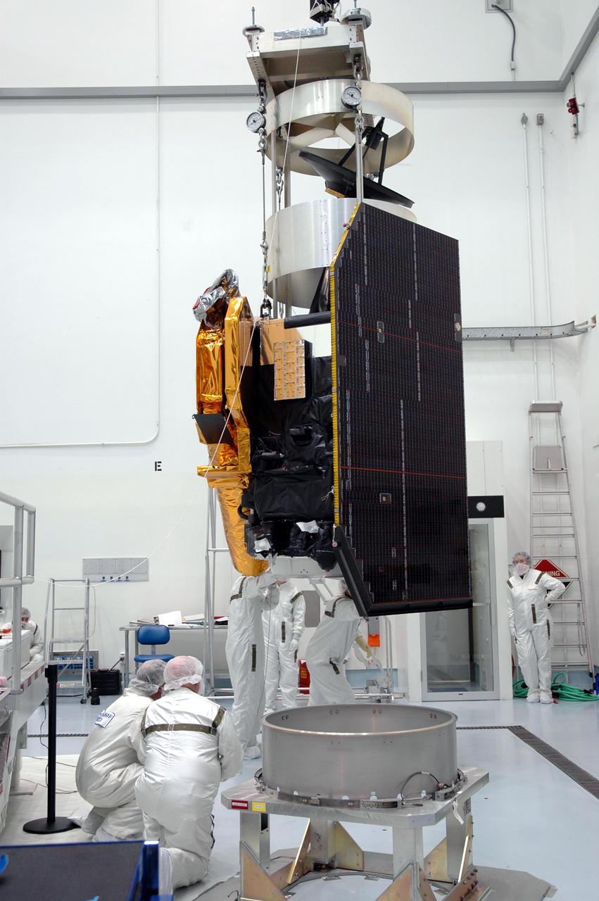 KENNEDY SPACE CENTER, FLA. - At Astrotech Space Operations in Titusville, Fla., Boeing technicians watch as an overhead crane lifts the Deep Impact spacecraft, which is being moved for mating to the Delta II third stage. When the spacecraft and third stage are mated, they will be moved to Launch Pad 17-B at Cape Canaveral Air Force Station, Fla.  There they will be mated to the Delta II rocket and the fairing installed around them for protection during launch and ascent.  Scheduled for liftoff Jan. 12,  Deep Impact will probe beneath the surface of Comet Tempel 1 on July 4, 2005, when the comet is 83 million miles from Earth.  After releasing a 3- by 3-foot projectile to crash onto the surface, Deep Impact’s flyby spacecraft will reveal the secrets of its interior by collecting pictures and data of how the crater forms, measuring the crater’s depth and diameter as well as the composition of the interior of the crater and any material thrown out, and determining the changes in natural outgassing produced by the impact.  It will send the data back to Earth through the antennas of the Deep Space Network.  Deep Impact is a NASA Discovery mission.