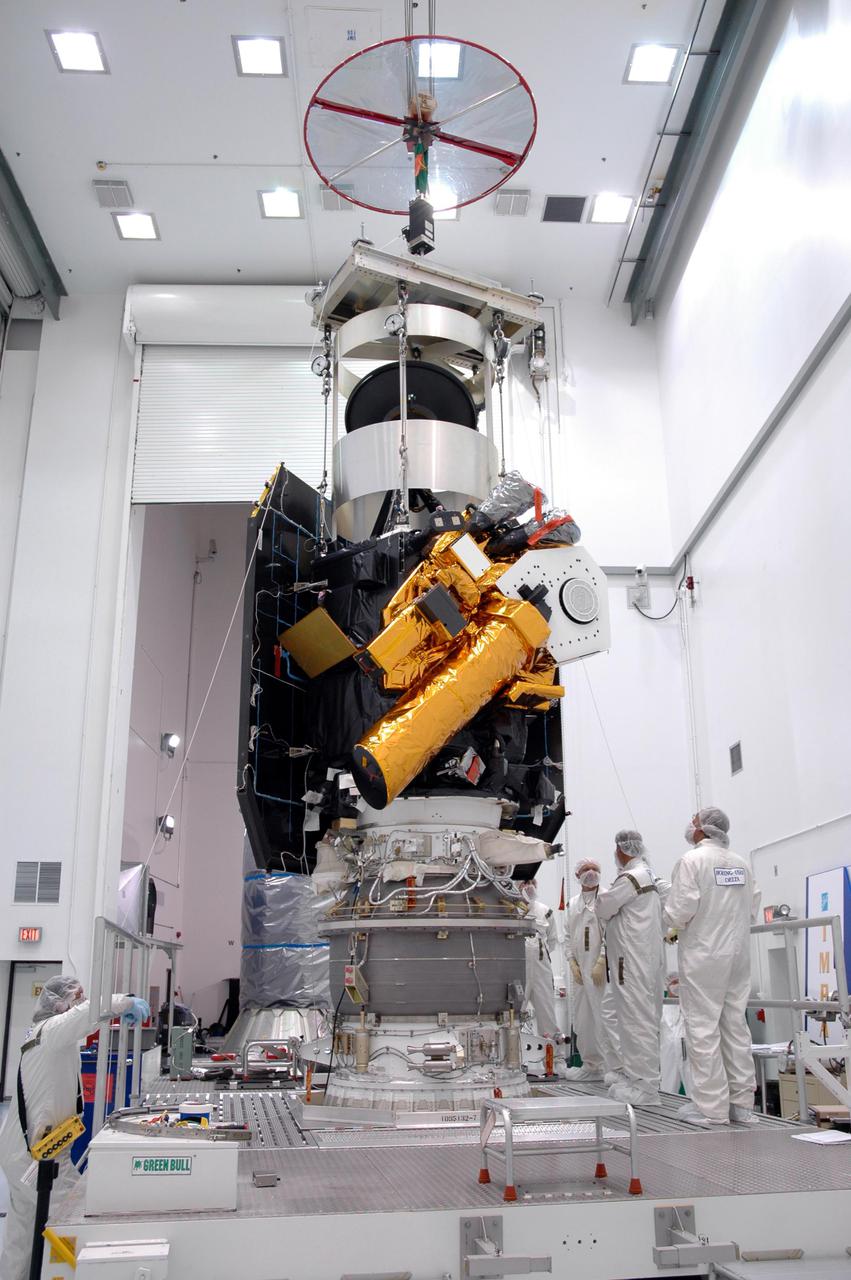 KENNEDY SPACE CENTER, FLA. - At Astrotech Space Operations in Titusville, Fla., the Deep Impact spacecraft is mated to the Boeing Delta II third stage. When the spacecraft and third stage are mated, they will be moved to Launch Pad 17-B at Cape Canaveral Air Force Station, Fla.  There they will be mated to the Delta II rocket and the fairing installed around them for protection during launch and ascent.  Scheduled for liftoff Jan. 12,  Deep Impact will probe beneath the surface of Comet Tempel 1 on July 4, 2005, when the comet is 83 million miles from Earth.  After releasing a 3- by 3-foot projectile to crash onto the surface, Deep Impact’s flyby spacecraft will reveal the secrets of its interior by collecting pictures and data of how the crater forms, measuring the crater’s depth and diameter as well as the composition of the interior of the crater and any material thrown out, and determining the changes in natural outgassing produced by the impact.  It will send the data back to Earth through the antennas of the Deep Space Network.  Deep Impact is a NASA Discovery mission.