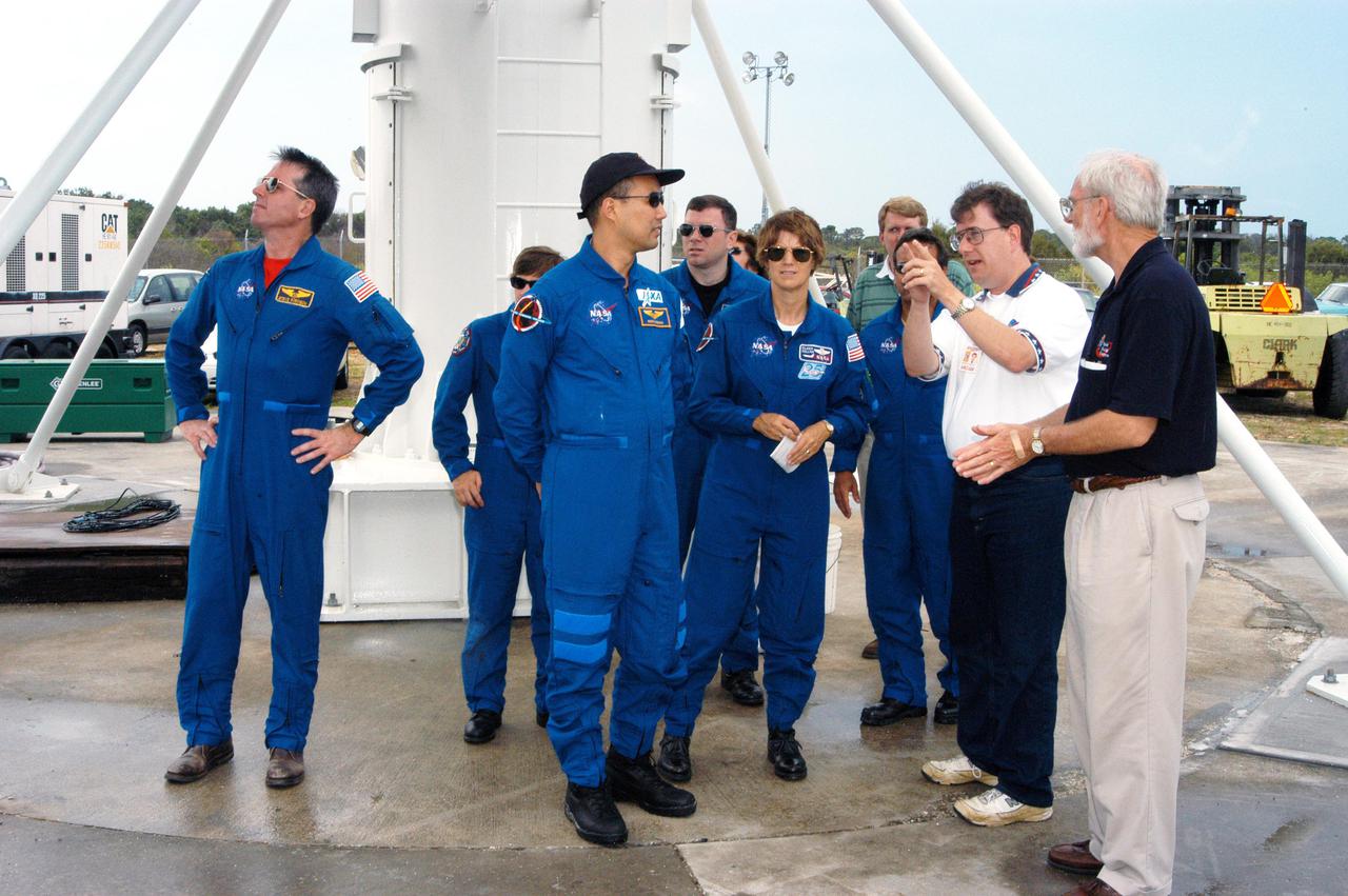 KENNEDY SPACE CENTER, FLA.  - Members of the STS-114 crew learn about a 30-foot-diameter C-band antenna (above them) and smaller X-band antenna being installed at KSC, north of the Haulover Canal.  From left are Mission Specialists Stephen Robinson, Wendy Lawrence (partially hidden) and Soichi Noguchi; Pilot James Kelly; Commander Eileen Collins; and Mission Specialist Charles Camarda (partially hidden).  At far right is Denny Kross, deputy Space Shuttle Program manager.  Next to him is Tony Griffith, JSC project manager for the Ascent Debris Radar Working Group.  The antennas are being tested during the launch of a Delta II rocket carrying NASA’s MESSENGER spacecraft bound for the planet Mercury that will work together to create an image of the Delta rocket in flight. The test will evaluate the use of the radars as part of NASA’s Return to Flight program for the Space Shuttle to observe possible debris coming from the Shuttle during launch.  If successful, the radar configuration could be used on ships downrange, including on one of the solid rocket booster retrieval ships.  And it may enable the return to launching Space Shuttles at night.  The launch window for Return to Flight mission STS-114 is May 12 through June 3, 2005.