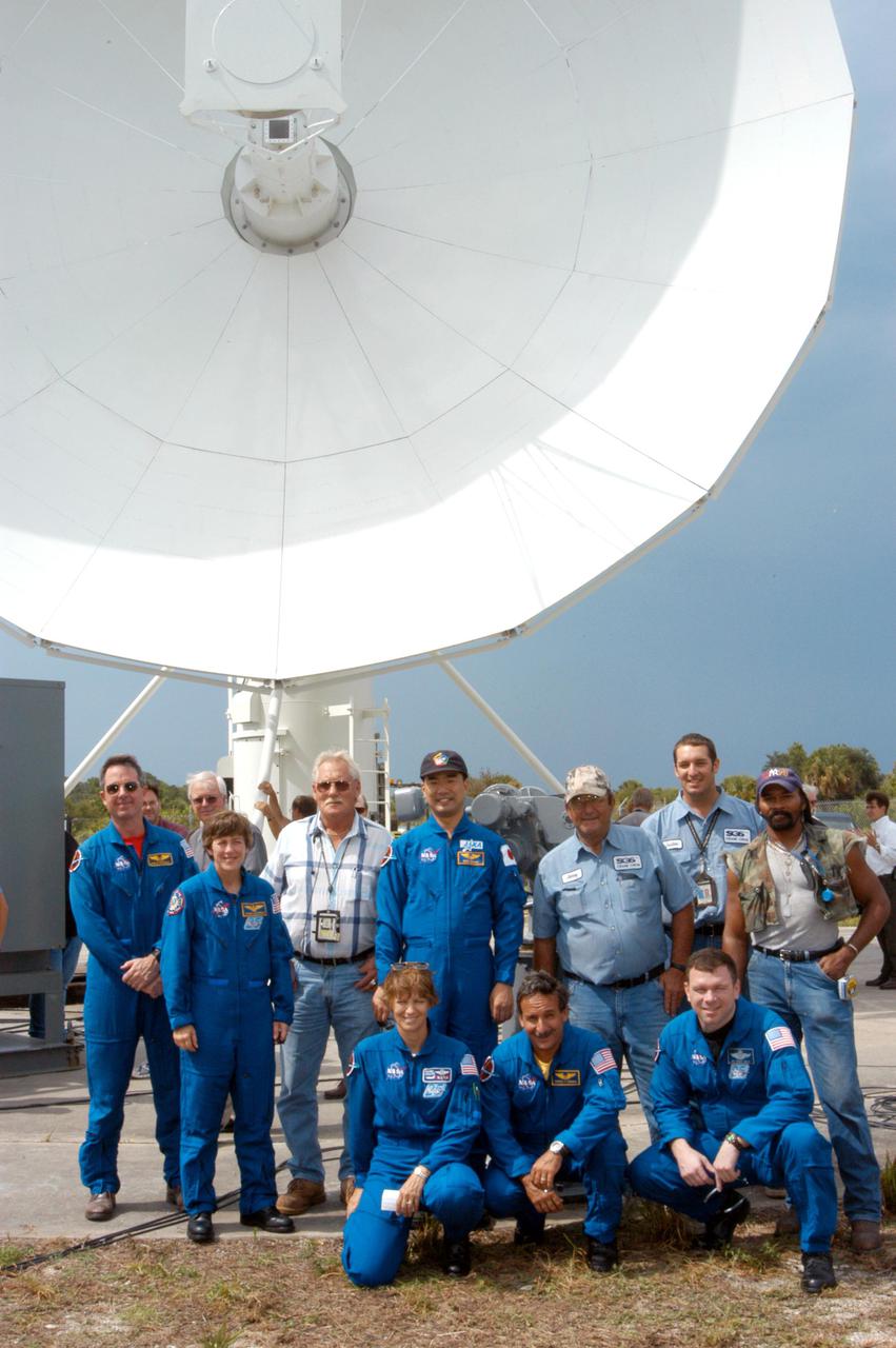 KENNEDY SPACE CENTER, FLA.  - Members of the STS-114 crew pose for a photo with workers installing the 30-foot-diameter C-band antenna (above them) and a smaller X-band antenna north of the Haulover Canal.  The astronauts are, standing from left, Mission Specialists Stephen Robinson, Wendy Lawrence and Soichi Noguchi; kneeling from left are Commander Eileen Collins, Mission Specialist Charles Camarda and Pilot James Kelly.  The antennas are being tested during the launch of a Delta II rocket carrying NASA’s MESSENGER spacecraft bound for the planet Mercury that will work together to create an image of the Delta rocket in flight. The test will evaluate the use of the radars as part of NASA’s Return to Flight program for the Space Shuttle to observe possible debris coming from the Shuttle during launch.  If successful, the radar configuration could be used on ships downrange, including on one of the solid rocket booster retrieval ships.  And it may enable the return to launching Space Shuttles at night.  The launch window for Return to Flight mission STS-114 is May 12 through June 3, 2005.