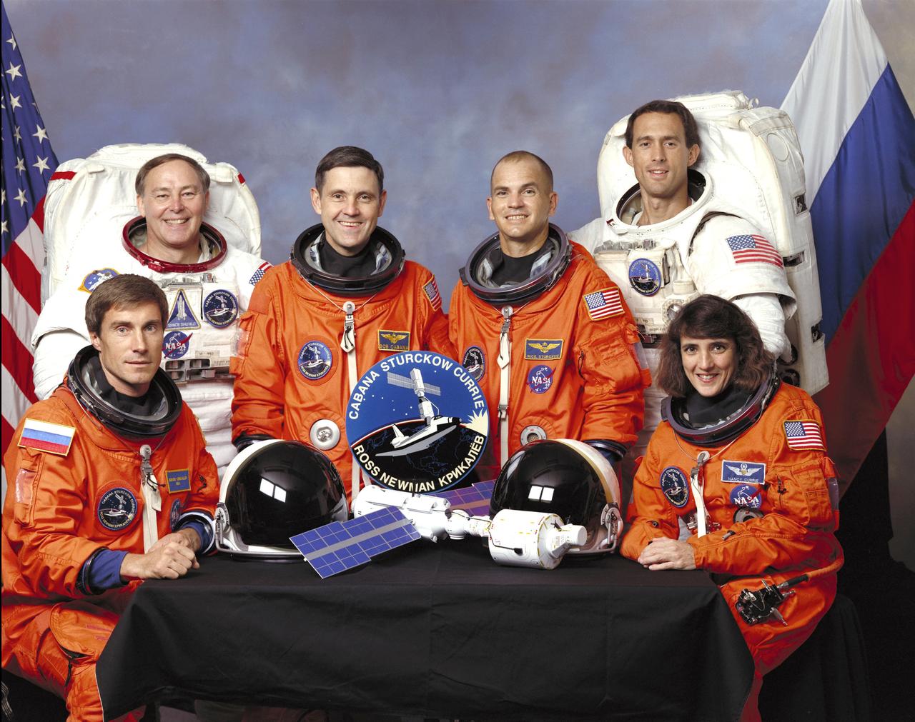 Five NASA astronauts and a Russian cosmonaut assigned to the STS-88 mission pose for a crew portrait. Seated in front (left to right) are mission specialists Sergei K. Krikalev, representing the Russian Space Agency (RSA), and astronaut Nancy J. Currie. In the rear from the left, are astronauts Jerry L. Ross, mission specialist; Robert D. Cabana, mission commander; Frederick W. “Rick” Sturckow, pilot; and James H. Newman, mission specialist. The STS-88 mission launched aboard the Space Shuttle Endeavor on December 4, 1998 at 2:35 a.m. (CST) to deliver the Unity Node to the International Space Station (ISS).