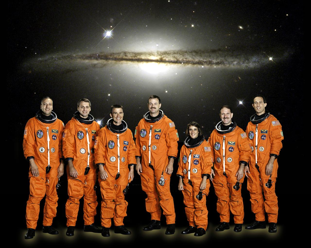 Posing for the traditional preflight crew portrait, the seven astronauts of the STS-109 mission are (left to right) astronauts Michael J. Massimino, Richard M. Linnehan, Duane G. Carey, Scott D. Altman, Nancy J. Currie, John M. Grunsfeld and James H. Newman. Altman and Carey were commander and pilot, respectively, with the others serving as mission specialists. Grunsfeld was payload commander. Launched aboard the Space Shuttle Columbia on March 1, 2002, the group was the fourth visit to the the Hubble Space Telescope (HST) for performing upgrade and servicing on the giant orbital observatory. 