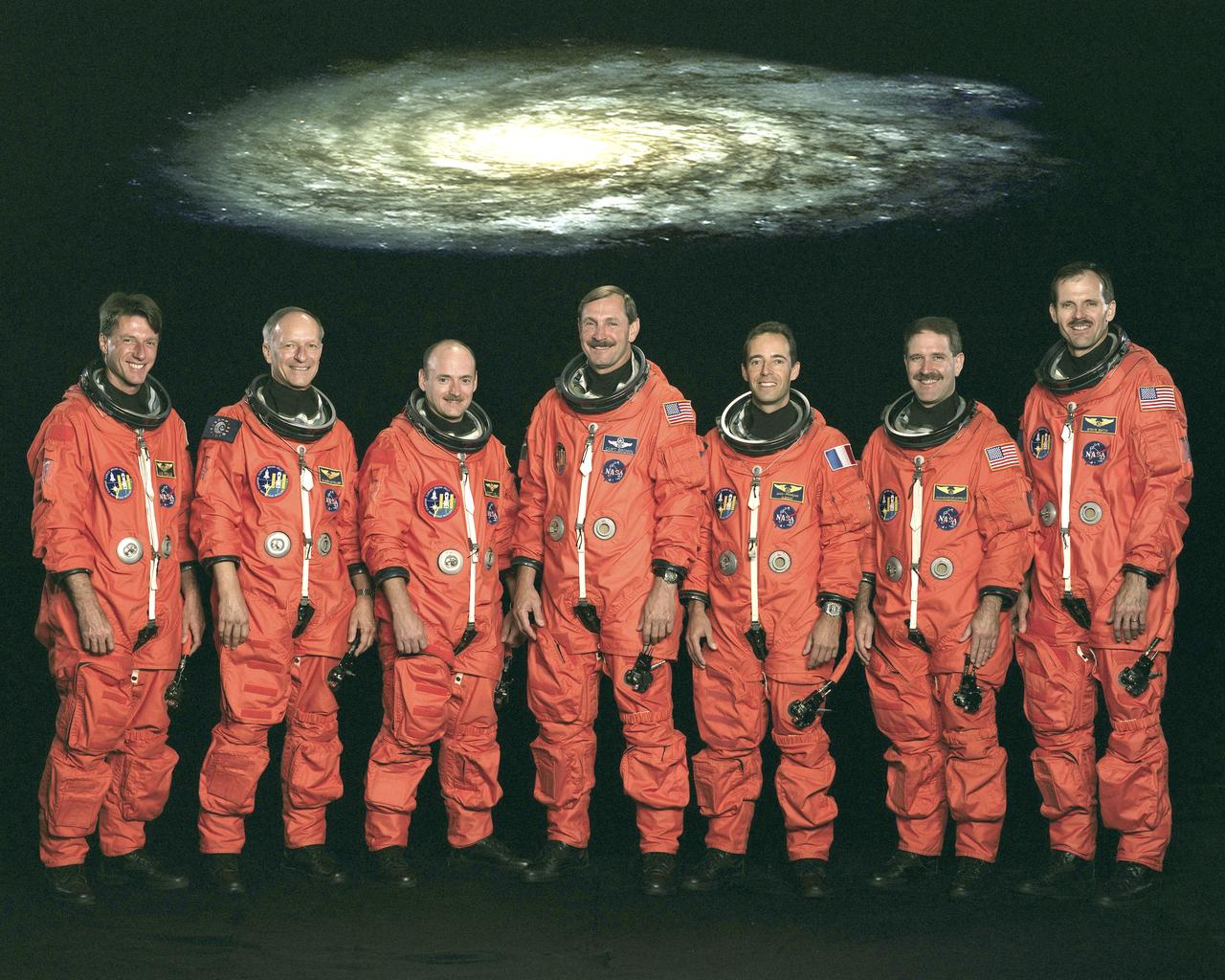 The STS-103 crew portrait includes (from left) C. Michael Foale, mission specialist; Claude Nicollier, mission specialist representing the European Space Agency (ESA) ; Scott J. Kelly, pilot; Curtis L. Brown, commander; and mission specialists Jean-Francois Clervoy (ESA), John M. Grunsfeld, and Steven L. Smith. Launched aboard the Space Shuttle Discovery on December 19, 1999 at 6:50 p.m. (CST), the STS-103 mission served as the third Hubble Space Telescope (HST) servicing mission.