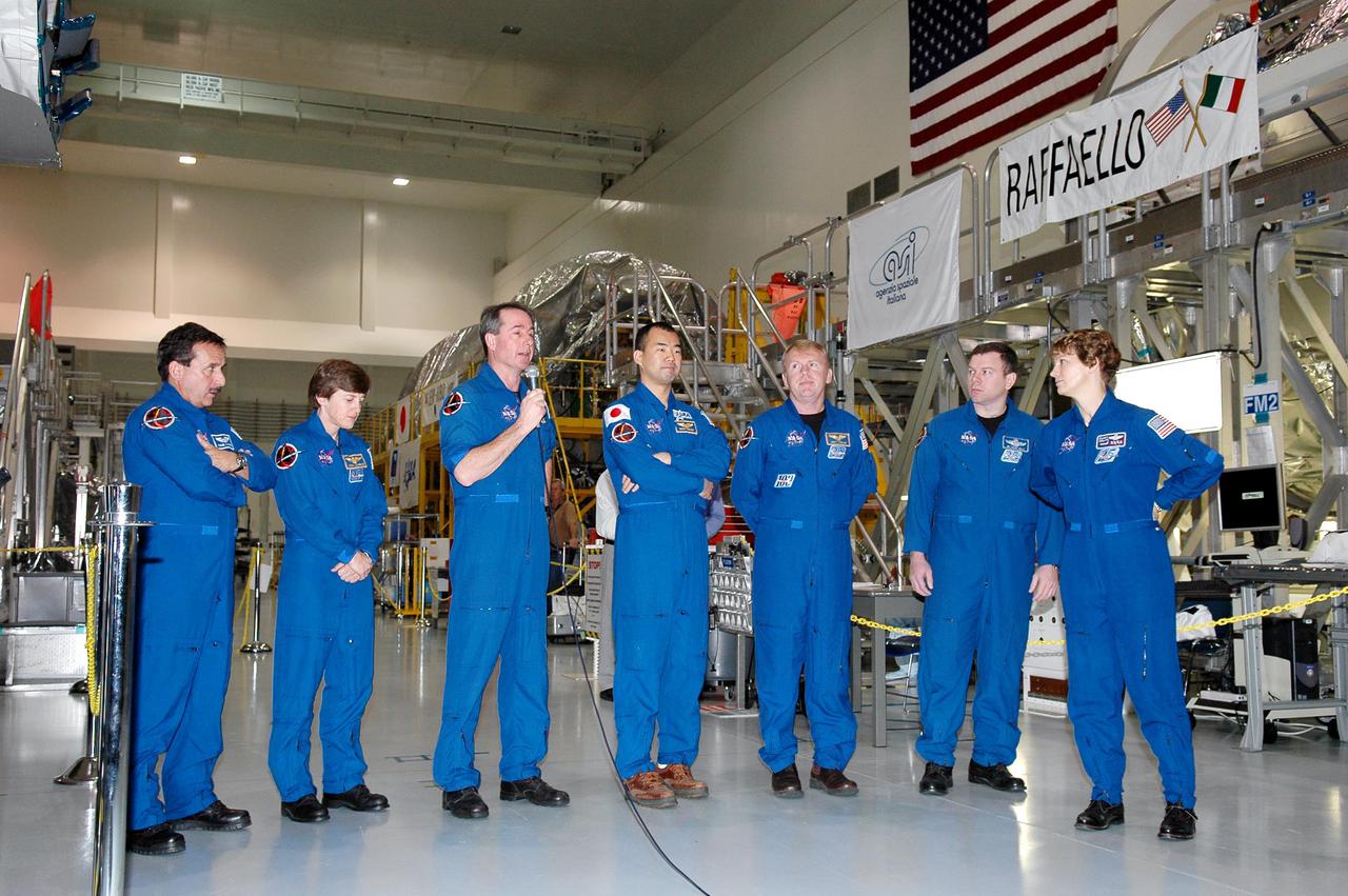 KENNEDY SPACE CENTER, FLA.  - After looking over some of the hardware in the Space Station Processing Facility, STS-114 crew members answer questions from the media.  From right are Mission Specialists Charles Camarda, Wendy Lawrence, Stephen Robinson (with the microphone), Soichi Noguchi (with the Japanese Space Agency) and Andrew Thomas; Pilot James Kelly; and Commander Eileen Collins.  They are standing in front of the Multi-Purpose Logistics Module Raffaello that will fly on mission STS-114. The crew is at KSC for Crew Equipment Interface Test (CEIT) activities.  During CEIT, the crew has an opportunity to get a hands-on look at the payloads with which they’ll be working on-orbit.  The Return to Flight mission STS-114 will also carry a replacement Control Moment Gyroscope.  Launch of STS-114 has a launch window of May 12 to June 3.