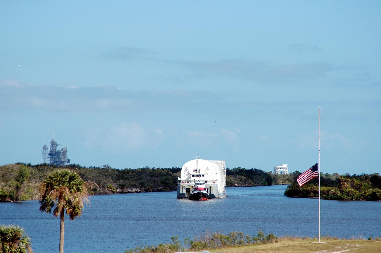 KENNEDY SPACE CENTER, FLA. - The newly redesigned External Tank, designated for use on Return to Flight mission STS-114, moves slowly toward its destination, the dock at the Launch Complex 39 Area Turn Basin, propelled by two tugboats. At left in the background is Launch Pad 39A. The External Tank arrived safely early this morning at Port Canaveral, Fla., after an approximately 900-mile journey at sea. It departed from the Michoud Assembly Facility in New Orleans Dec. 31 and was transported on the Pegasus, NASA’s specially designed barge, pulled by Solid Rocket Booster retrieval ship Liberty Star. At the port, the barge was then hooked up to the tugs for the last part of the journey to the Turn Basin. Next, the External Tank will be off-loaded from the barge and transported to the Vehicle Assembly Building for its final checkout and mating to the twin Solid Rocket Boosters and orbiter Discovery. NASA and Lockheed Martin Corp. spent nearly two years modifying the 15-story, bronze-colored tank to make it safer for liftoff. Among dozens of changes is a redesigned forward bipod fitting -- a design that meets the recommendation of the Columbia Accident Investigation Board to reduce the risk to the Space Shuttle from falling debris during ascent. STS-114 is targeted for a launch opportunity beginning in May. The seven-member Discovery crew will fly to the International Space Station primarily to test and evaluate new procedures for flight safety, including Space Shuttle inspection and repair techniques.