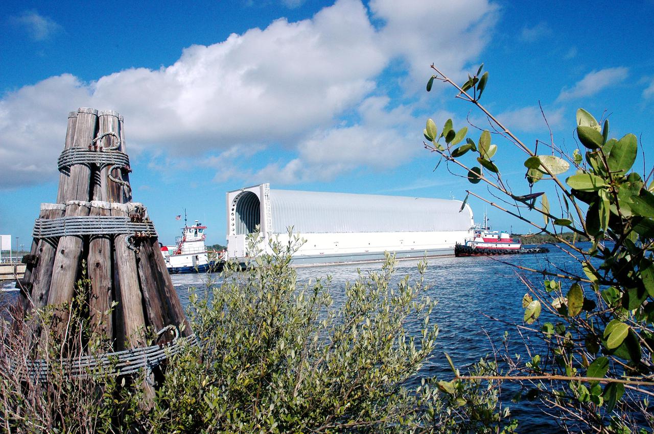 KENNEDY SPACE CENTER, FLA. - - Tugboats maneuver the barge carrying the newly redesigned External Tank, designated for use on Return to Flight mission STS-114, toward the dock at the Launch Complex 39 Area Turn Basin at Kennedy. The barge arrived after an approximately 900-mile journey at sea from the Michoud Assembly Facility in New Orleans. It left the facility Dec. 31 on the Pegasus, NASA’s specially designed barge, towed by Solid Rocket Booster retrieval ship Liberty Star. At Port Canaveral, the barge was then hooked up to the tugs for the last part of the journey. Next, the External Tank will be off-loaded from the barge and transported to the Vehicle Assembly Building for its final checkout and mating to the twin Solid Rocket Boosters and orbiter Discovery. NASA and Lockheed Martin Corp. spent nearly two years modifying the 15-story, bronze-colored tank to make it safer for liftoff. Among dozens of changes is a redesigned forward bipod fitting -- a design that meets the recommendation of the Columbia Accident Investigation Board to reduce the risk to the Space Shuttle from falling debris during ascent. STS-114 is targeted for a launch opportunity beginning in May. The seven-member Discovery crew will fly to the International Space Station primarily to test and evaluate new procedures for flight safety, including Space Shuttle inspection and repair techniques.