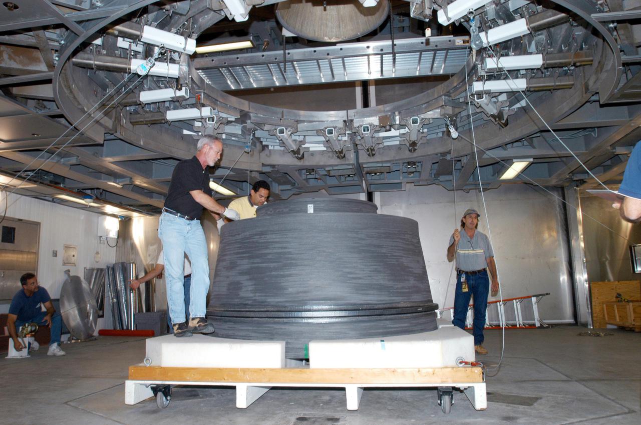 KENNEDY SPACE CENTER, FLA. - At the Delta Operations Center, Jack Reynolds and Leslie Guzman (both at left), with Pratt and Whitney, prepare the nozzle for the RL-10 engine to be attached to the second stage of the Boeing Delta IV rocket.  The Delta IV is the launch vehicle for the Geostationary Operational Environmental Satellite (GOES-N), scheduled to launch in April 2005 from Cape Canaveral Air Force Station.  GOES-N is a weather satellite for NASA and NOAA (National Oceanic and Atmospheric Administration).  The first in a series of three advanced weather satellites including GOES-O and GOES-P, the GOES-N will provide continuous monitoring necessary for intensive data analysis. It will provide a constant vigil for the atmospheric “triggers” of severe weather conditions such as tornadoes, flash floods, hail storms and hurricanes. When these conditions develop, GOES-N will be able to monitor storm development and track their movements.