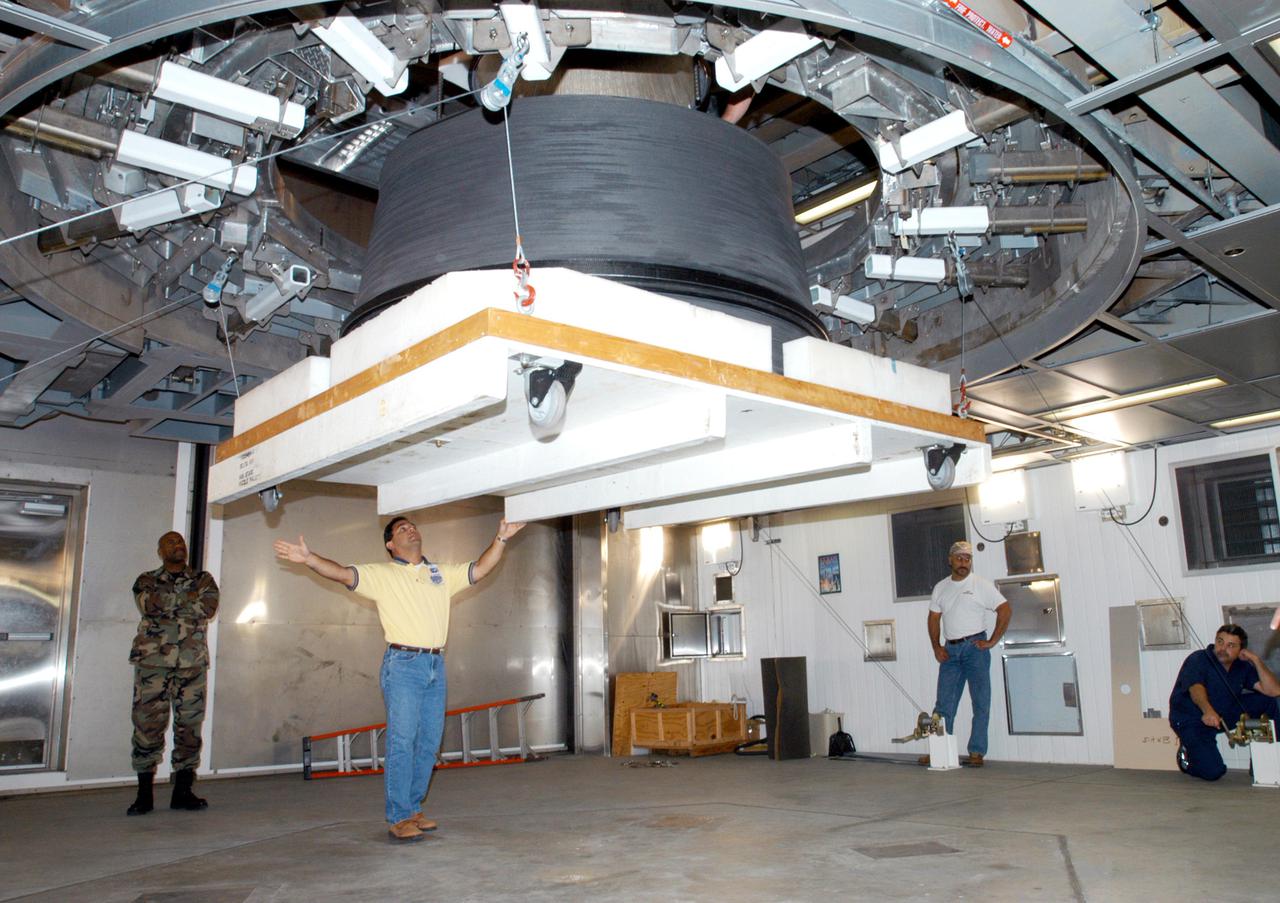 KENNEDY SPACE CENTER, FLA. - At the Delta Operations Center, Leslie Guzman (yellow shirt), with Pratt and Whitney, watches closely as the nozzle for the RL-10 engine is lifted into place on the second stage of the Boeing Delta IV rocket. The Delta IV is the launch vehicle for the Geostationary Operational Environmental Satellite (GOES-N), scheduled to launch in April 2005 from Cape Canaveral Air Force Station. GOES-N is a weather satellite for NASA and NOAA (National Oceanic and Atmospheric Administration). The first in a series of three advanced weather satellites including GOES-O and GOES-P, the GOES-N will provide continuous monitoring necessary for intensive data analysis. It will provide a constant vigil for the atmospheric “triggers” of severe weather conditions such as tornadoes, flash floods, hail storms and hurricanes. When these conditions develop, GOES-N will be able to monitor storm development and track their movements.