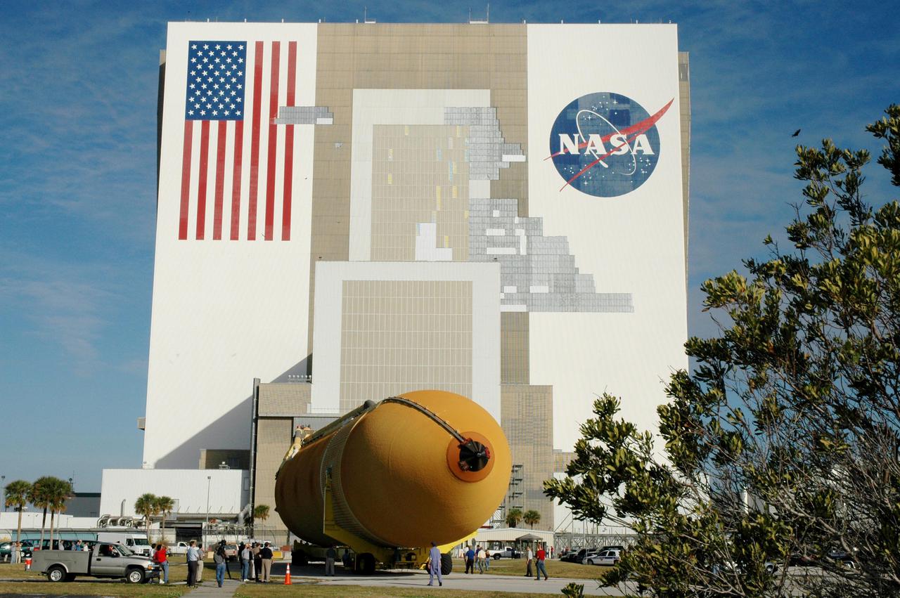 KENNEDY SPACE CENTER, FLA. - The newly redesigned External Tank heads for the open doors of the Vehicle Assembly Building, seen behind it.  The tank arrived Jan. 5 after a 900-mile sea voyage aboard NASA’s specially designed barge, Pegasus, from the Michoud Assembly Facility in New Orleans.  In the transfer aisle of the VAB, the tank will be raised from a horizontal to a vertical position, then lifted high up into a storage cell, or “checkout cell,” where it will undergo inspections of the mechanical, electrical and thermal protection systems.  New processing activities resulting from re-design of the tank include inspection of the bipod heater and External Tank separation camera, which includes charging the camera batteries.  The tank will be then prepared for mating to the Solid Rocket Boosters.  When preparations are complete, the tank will be lifted from the checkout cell, moved across the transfer aisle and into High Bay 1, where it will be lowered and attached to the boosters, which are sitting on the Mobile Launch Platform.  The tank is designated for the Return to Flight mission, STS-114,  targeted for a launch opportunity beginning in May. The seven-member Discovery crew will fly to the International Space Station primarily to test and evaluate new procedures for flight safety, including Space Shuttle inspection and repair techniques.