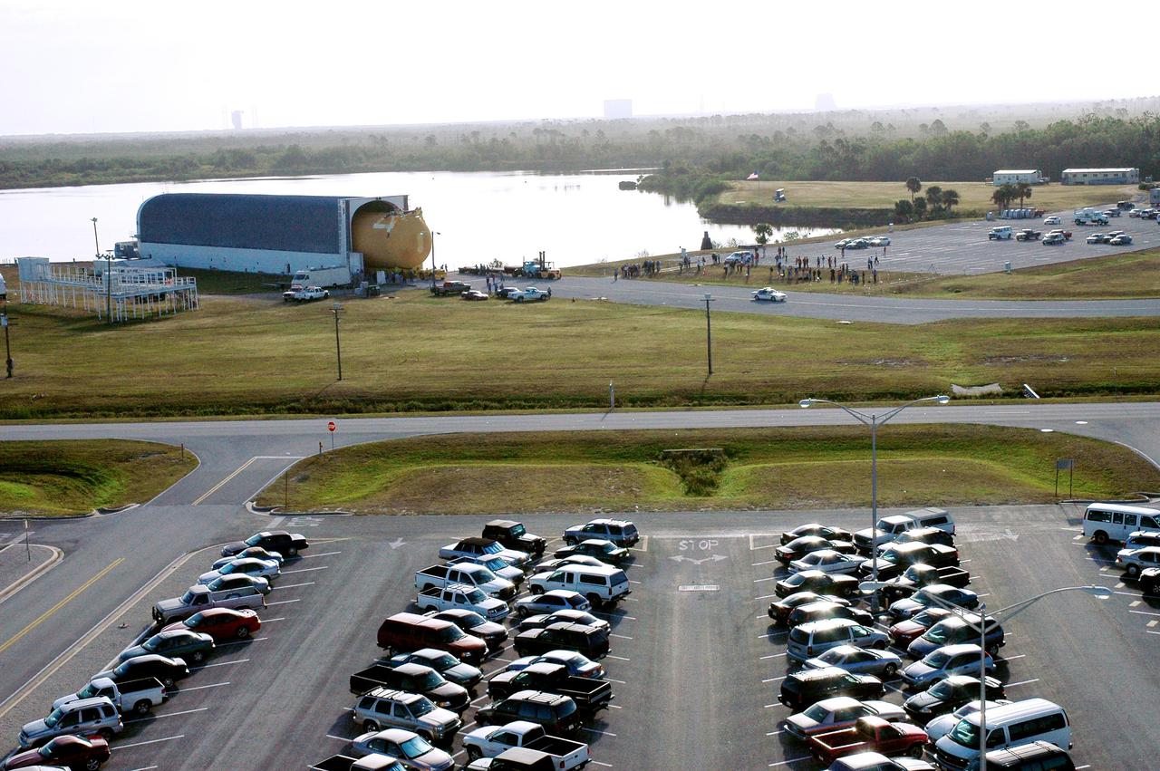 KENNEDY SPACE CENTER, FLA. - Viewed from the top of the Launch Control Center, the newly redesigned External Tank is seen moving out of NASA’s specially designed barge, Pegasus, which delivered it from the Michoud Assembly Facility in New Orleans. The tank is being transferred to the Vehicle Assembly Building. In the transfer aisle of the VAB, the tank will be raised from a horizontal to a vertical position, then lifted high up into a storage cell, or “checkout cell,” where it will undergo inspections of the mechanical, electrical and thermal protection systems. New processing activities resulting from re-design of the tank include inspection of the bipod heater and External Tank separation camera, which includes charging the camera batteries. The tank will be then prepared for mating to the Solid Rocket Boosters. When preparations are complete, the tank will be lifted from the checkout cell, moved across the transfer aisle and into High Bay 1, where it will be lowered and attached to the boosters, which are sitting on the Mobile Launch Platform. The tank is designated for the Return to Flight mission, STS-114, targeted for a launch opportunity beginning in May. The seven-member Discovery crew will fly to the International Space Station primarily to test and evaluate new procedures for flight safety, including Space Shuttle inspection and repair techniques.