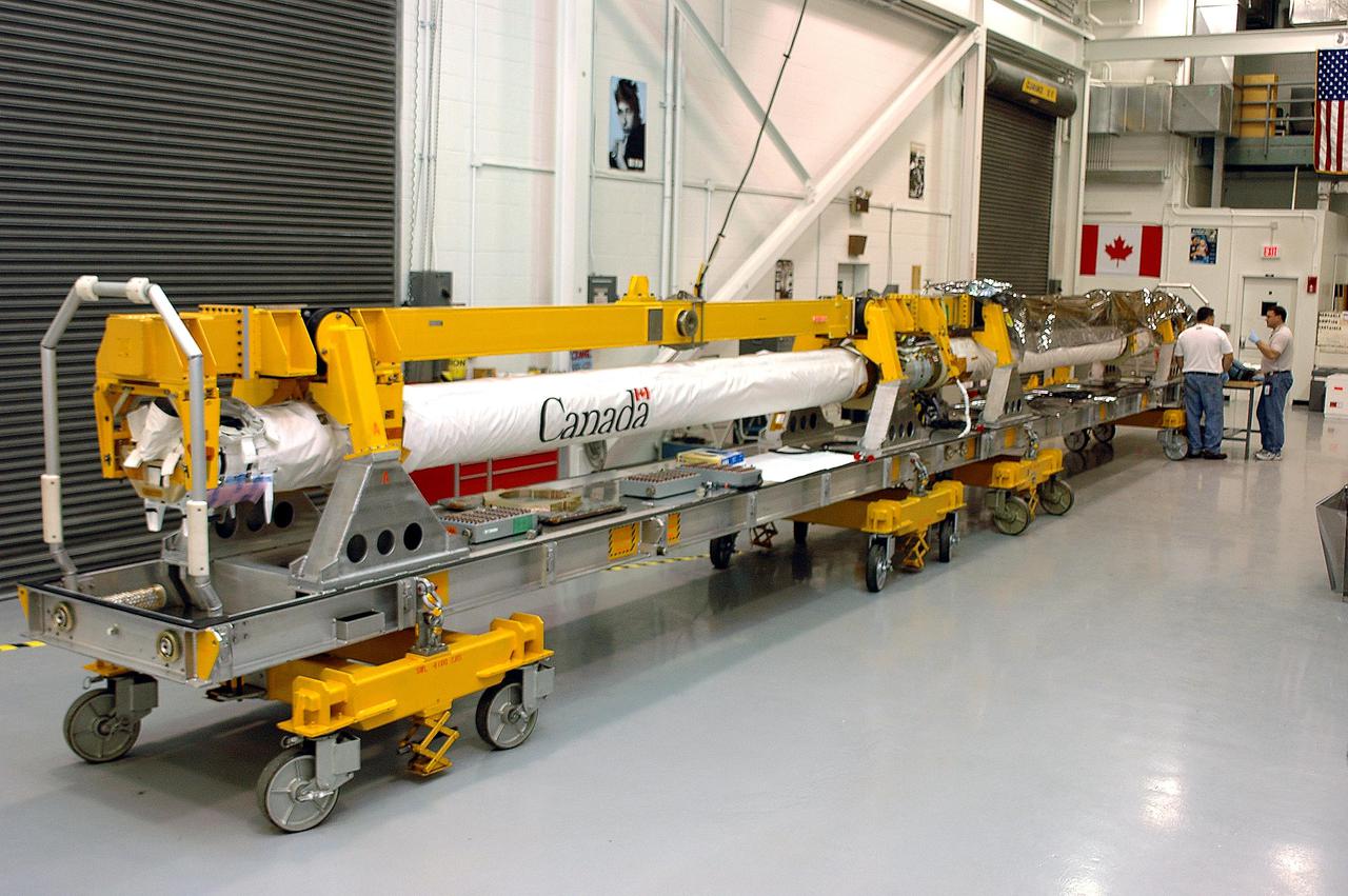 KENNEDY SPACE CENTER, FLA. - In the Remote Manipulator System lab, United Space Alliance technicians Jake Senior and Todd Dugan work on the Orbiter Boom Sensor System. The OBSS is undergoing final checkout and testing in the lab prior to being transferred to the Orbiter Processing Facility for installation on Space Shuttle Discovery. The 50-foot-long OBSS will be attached to the Remote Manipulator System, or Shuttle arm, and is one of the new safety measures for Return to Flight, equipping the orbiter with cameras and laser systems to inspect the Shuttle's Thermal Protection System while in space. Discovery is slated to fly mission STS-114 once Space Shuttle launches resume. The launch planning window is May 12 to June 3, 2005.