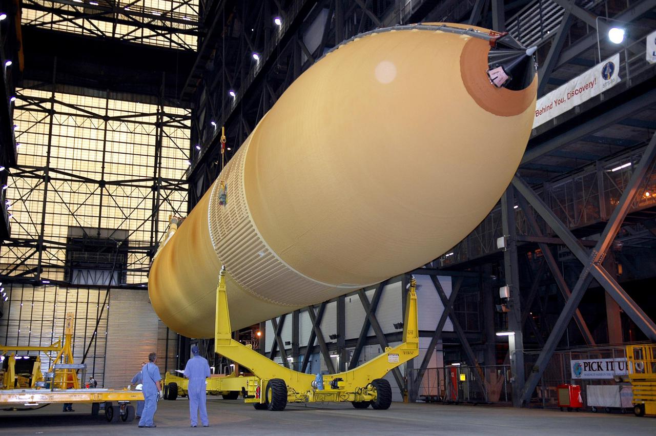 KENNEDY SPACE CENTER, FLA. - The redesigned External Tank is being raised off its transporter.  It will be lifted to a vertical position and into the 'checkout cell' of the Vehicle Assembly Building where the tank’s mechanical, electrical and thermal protection systems are inspected.  The tank will also undergo new processes resulting from its redesign, including inspection of the bipod heater and External Tank separation camera. The tank will be prepared for 'mating' to the Shuttle’s Solid Rocket Boosters. When preparations are complete, the tank will be lifted from the checkout cell, moved across the transfer aisle and into High Bay 1. It will be lowered and attached to the boosters, which are sitting on the Mobile Launch Platform.  The SRBs and ET will be flying with Shuttle Discovery for the Return to Flight mission STS-114.  The launch planning window is May 12 to June 3, 2005.