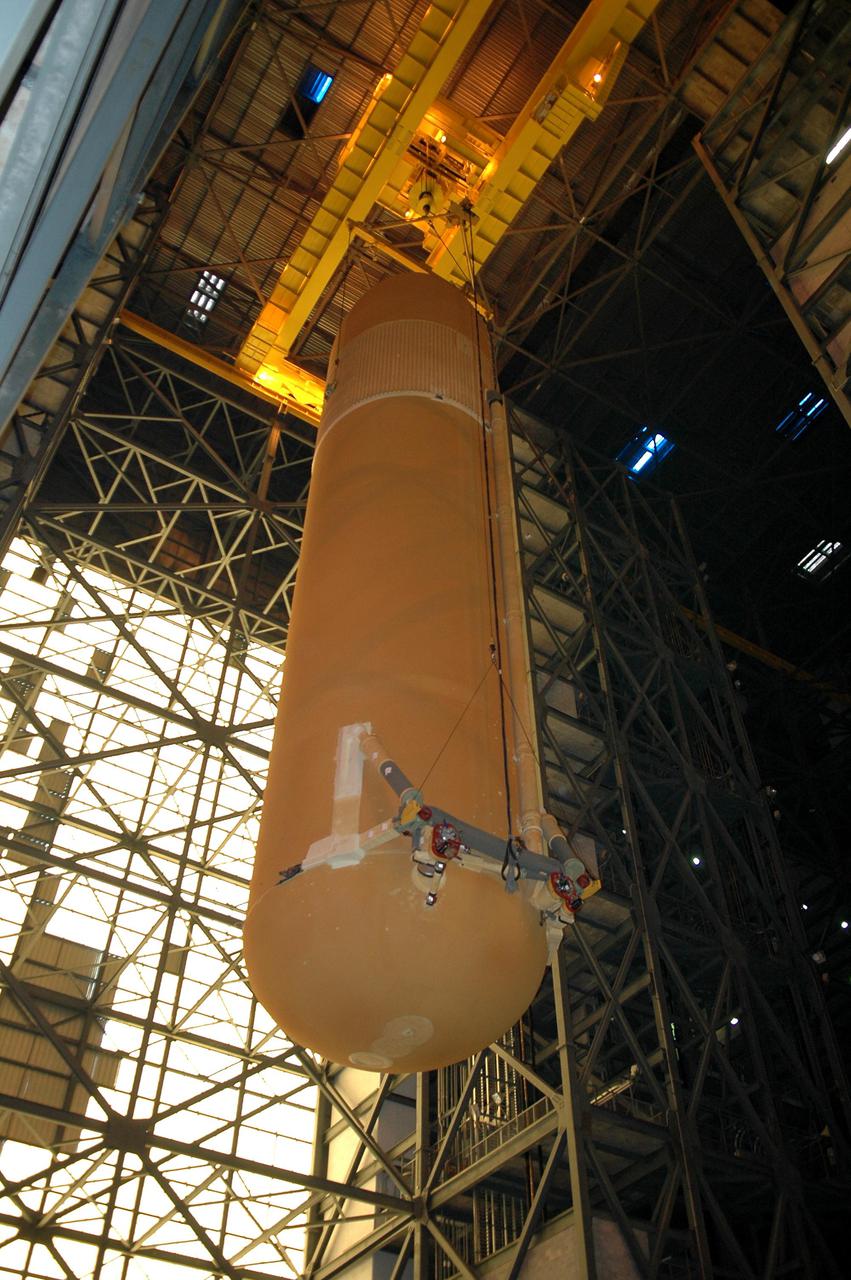 KENNEDY SPACE CENTER, FLA. - Viewed from the floor of the Vehicle Assembly Building, the redesigned External Tank is seen being lifted to the top where it will be lifted into the 'checkout cell' where the tank’s mechanical, electrical and thermal protection systems are inspected. The tank will also undergo new processes resulting from its redesign, including inspection of the bipod heater and External Tank separation camera. The tank will be prepared for 'mating' to the Shuttle’s Solid Rocket Boosters. When preparations are complete, the tank will be lifted from the checkout cell, moved across the transfer aisle and into High Bay 1. It will be lowered and attached to the boosters, which are sitting on the Mobile Launch Platform.  The SRBs and ET will be flying with Shuttle Discovery for the Return to Flight mission STS-114.  The launch planning window is May 12 to June 3, 2005.