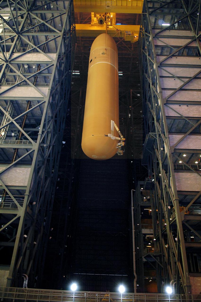 KENNEDY SPACE CENTER, FLA. - Viewed from the floor of the Vehicle Assembly Building, the redesigned External Tank is seen being lifted to the top where it will be lifted into the 'checkout cell' where the tank’s mechanical, electrical and thermal protection systems are inspected.  The tank will also undergo new processes resulting from its redesign, including inspection of the bipod heater and External Tank separation camera. The tank will be prepared for 'mating' to the Shuttle’s Solid Rocket Boosters. When preparations are complete, the tank will be lifted from the checkout cell, moved across the transfer aisle and into High Bay 1. It will be lowered and attached to the boosters, which are sitting on the Mobile Launch Platform.  The SRBs and ET will be flying with Shuttle Discovery for the Return to Flight mission STS-114.  The launch planning window is May 12 to June 3, 2005.