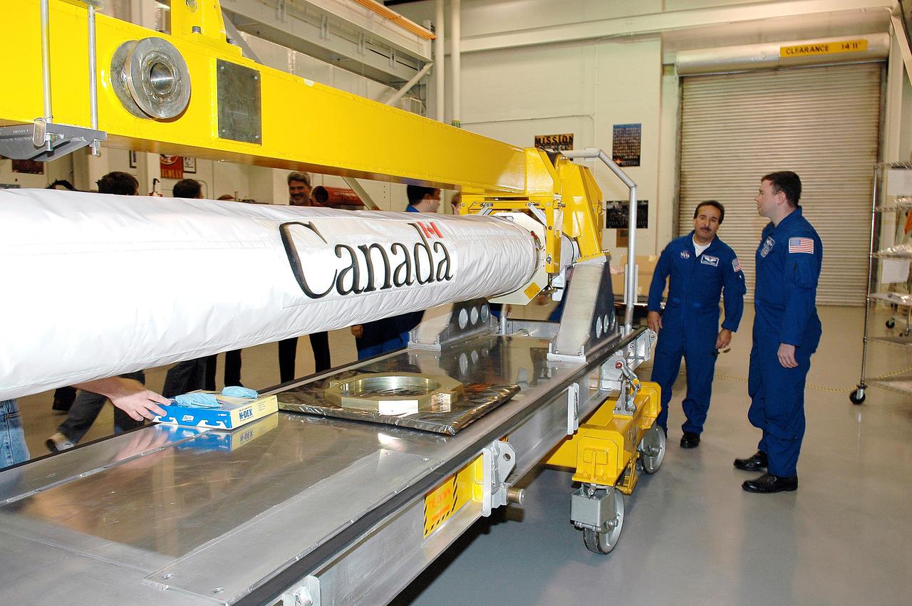 KENNEDY SPACE CENTER, FLA. - In the Remote Manipulator Lab inside the Vehicle Assembly Building, STS-114 Mission Specialist Charles Camarda (left) and Pilot James Kelly look at the new 50-foot-long Orbiter Boom Sensor System (OBSS) that will fly on Shuttle Discovery on Return to Flight mission STS-114. The OBSS attaches to the end of the Shuttle’s robotic arm. The system is one of the new safety measures for Return to Flight, equipping the orbiter with cameras and laser systems to inspect the Shuttle's Thermal Protection System while in space. Crew members are at Kennedy to become familiar with Shuttle equipment such as the OBSS and the newly redesigned External Tank. The launch window is May 12 to June 3, 2005.