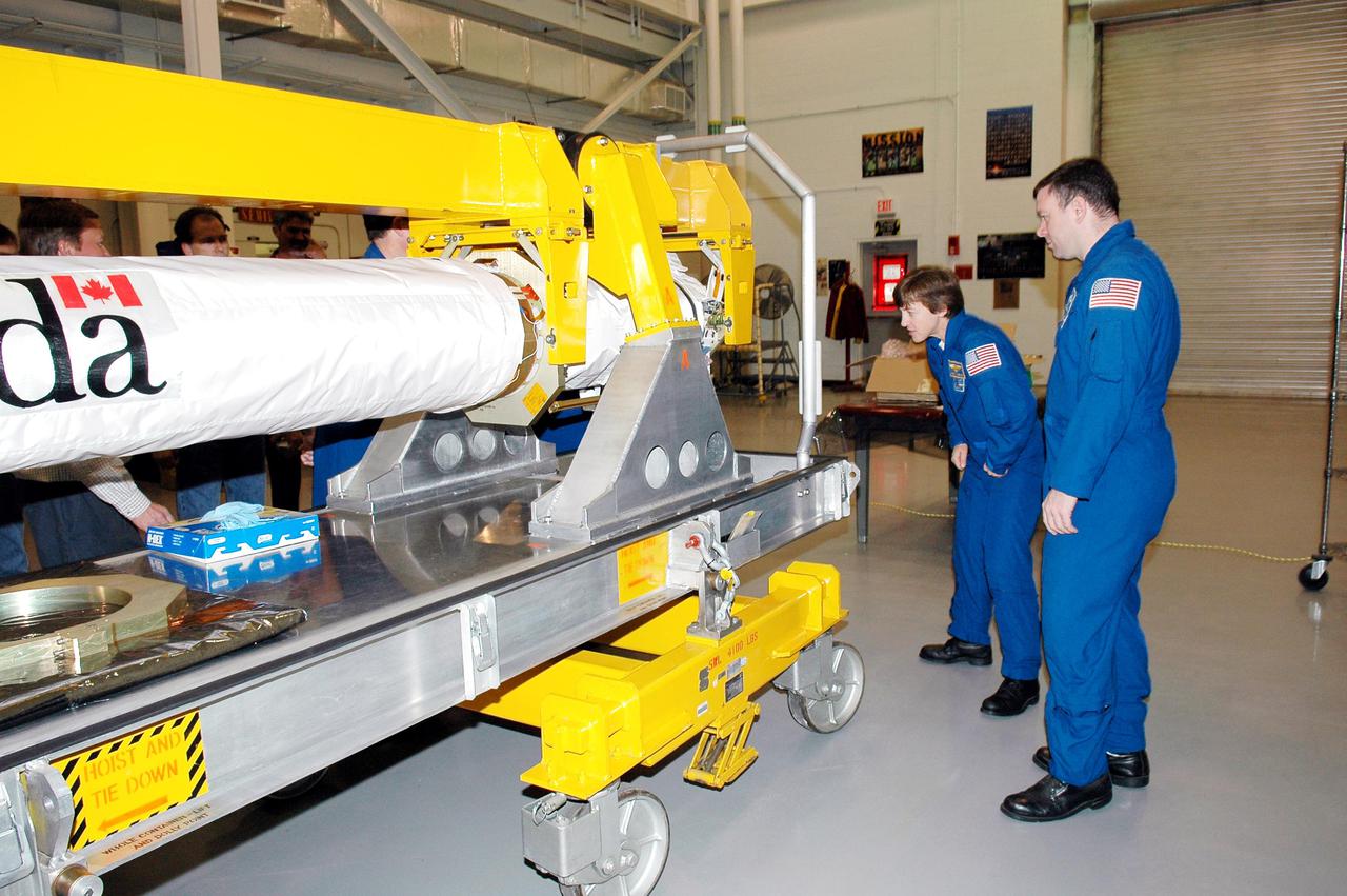 KENNEDY SPACE CENTER, FLA. - In the Remote Manipulator Lab inside the Vehicle Assembly Building, STS-114 Mission Specialist Wendy Lawrence and Pilot James Kelly look at the new 50-foot-long Orbiter Boom Sensor System (OBSS) that will fly on Shuttle Discovery on Return to Flight mission STS-114. The OBSS attaches to the end of the Shuttle’s robotic arm. The system is one of the new safety measures for Return to Flight, equipping the orbiter with cameras and laser systems to inspect the Shuttle's Thermal Protection System while in space. Crew members are at Kennedy to become familiar with Shuttle equipment such as the OBSS and the newly redesigned External Tank. The launch window is May 12 to June 3, 2005.